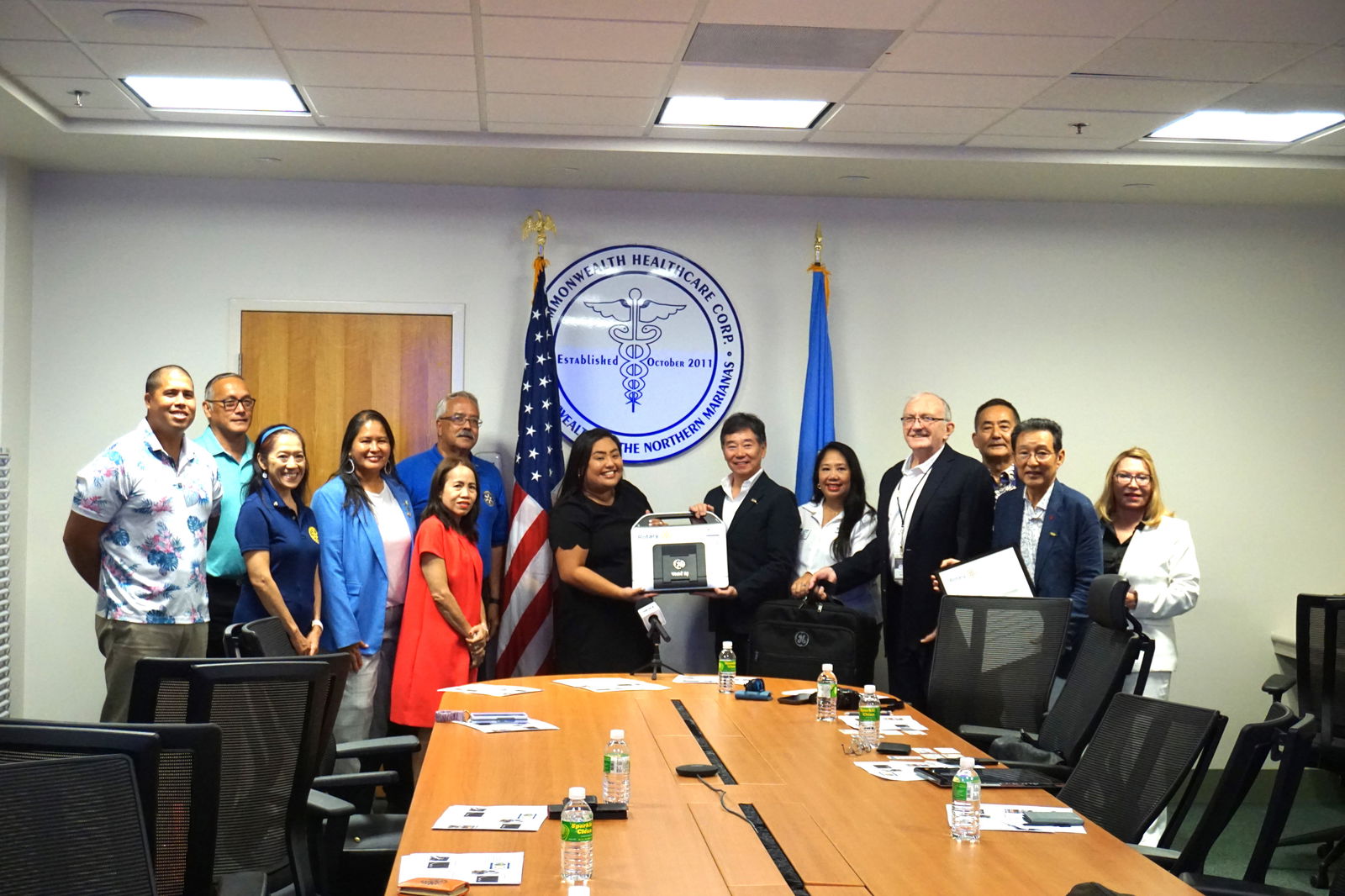 Halina Palacios, center left, CHCC corporate operations officer for population health, receives a portable echocardiogram machine from Jun Kono, Rotary Club of Tokyo-West president. Also in photo are other Rotarians.