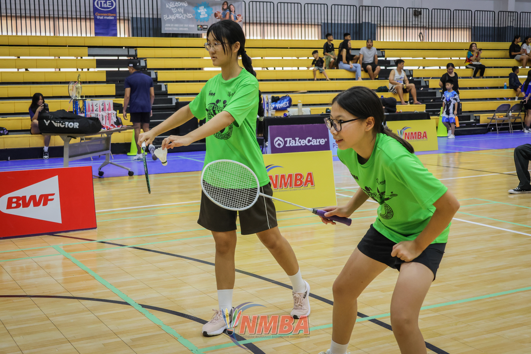 Elim Nga Lam Luo and Rebecca Wu prepare for the serve against ACS 2 during the championship match in the co-ed middle school division of the PSS-NMBA Interscholastic Badminton League SY24-25 at the Ada gym on Saturday.