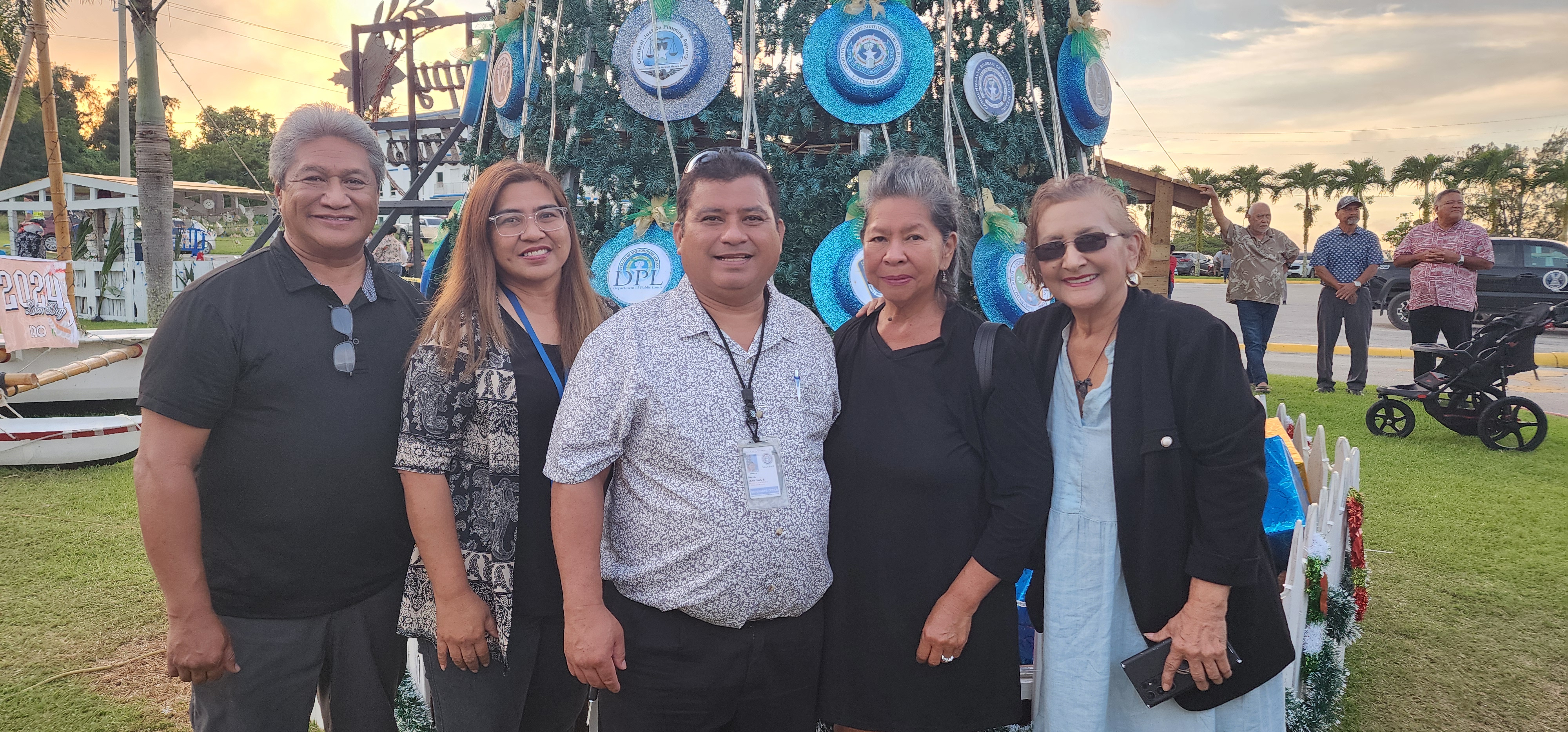 Acting Special Assistant for Administration John Paul Reyes, center, Office of the Governor Protocol Officer Ignacia Evangelista, second left, Marcie Rabauliman, wife of Department of Community and Cultural Affairs Secretary Frank Rabauliman, second right, First Lady Wella Foundation President Becky P. Cruz, right, and special assistant for Substance Abuse Addiction and Rehabilitation Program Diego M. Sablan pose for photo prior to the “Santa’s Sealand” Christmas lighting festivity on the grounds of the administration building on Capital Hill, Dec. 6, 2024.