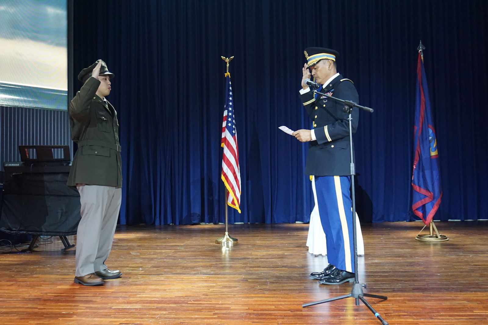 Franklin Babauta Sr., right, reads the oath of a commissioned officer to his son.