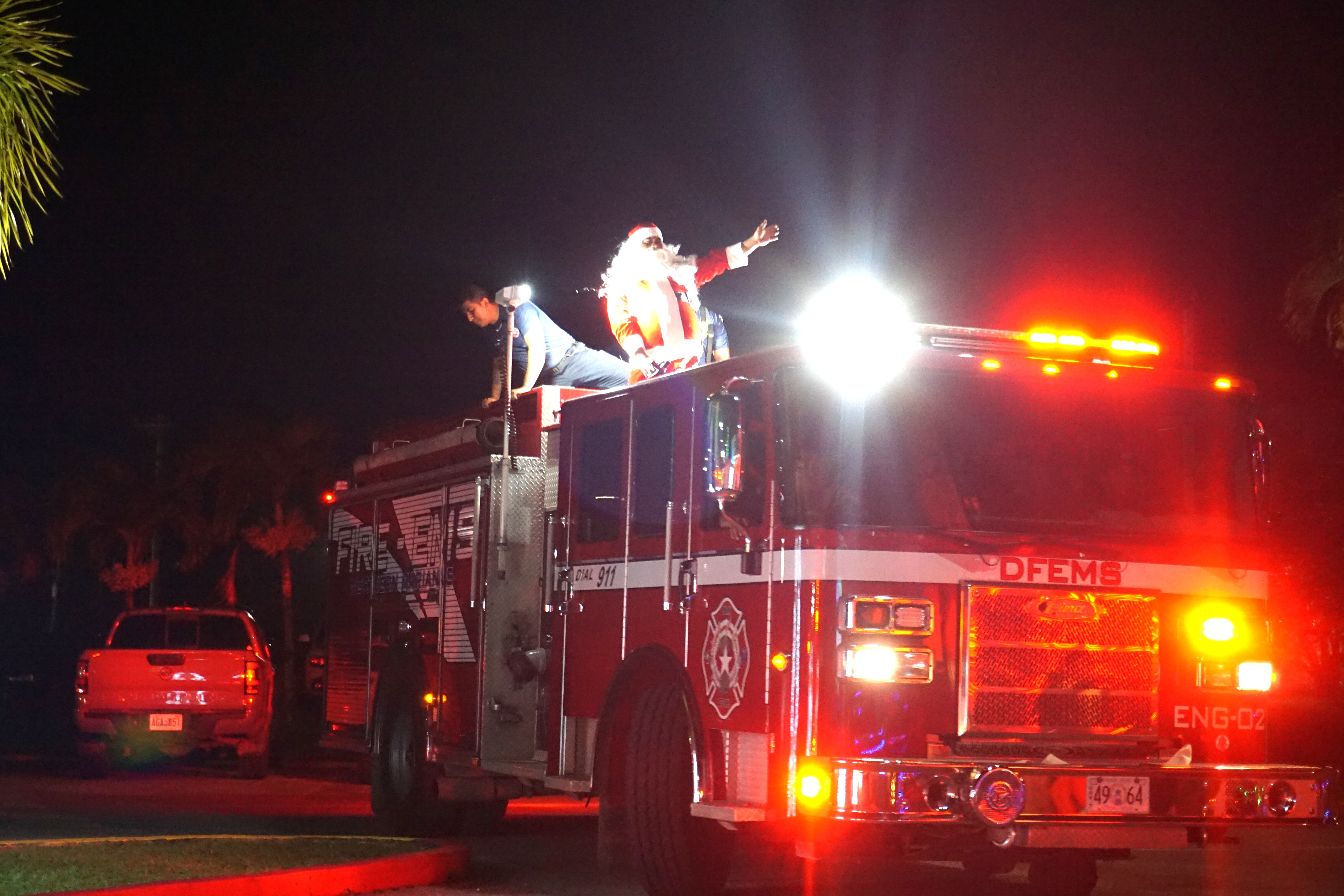 Santa Claus arrives on a fire truck.