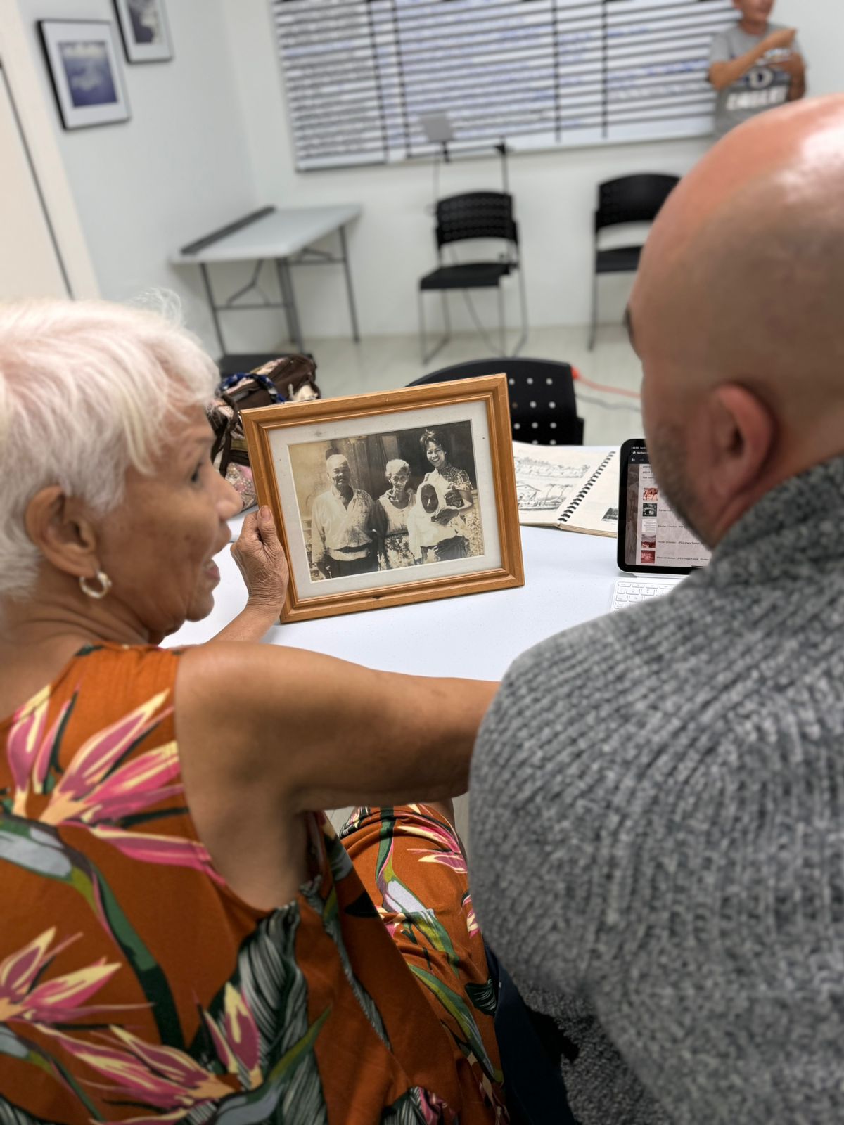 Rosa “Chailang” Palacios shares information with Archive Manager Roberto Santos about an old photograph of herself with her late parents that will be added to her own collection on the Digital Archives.