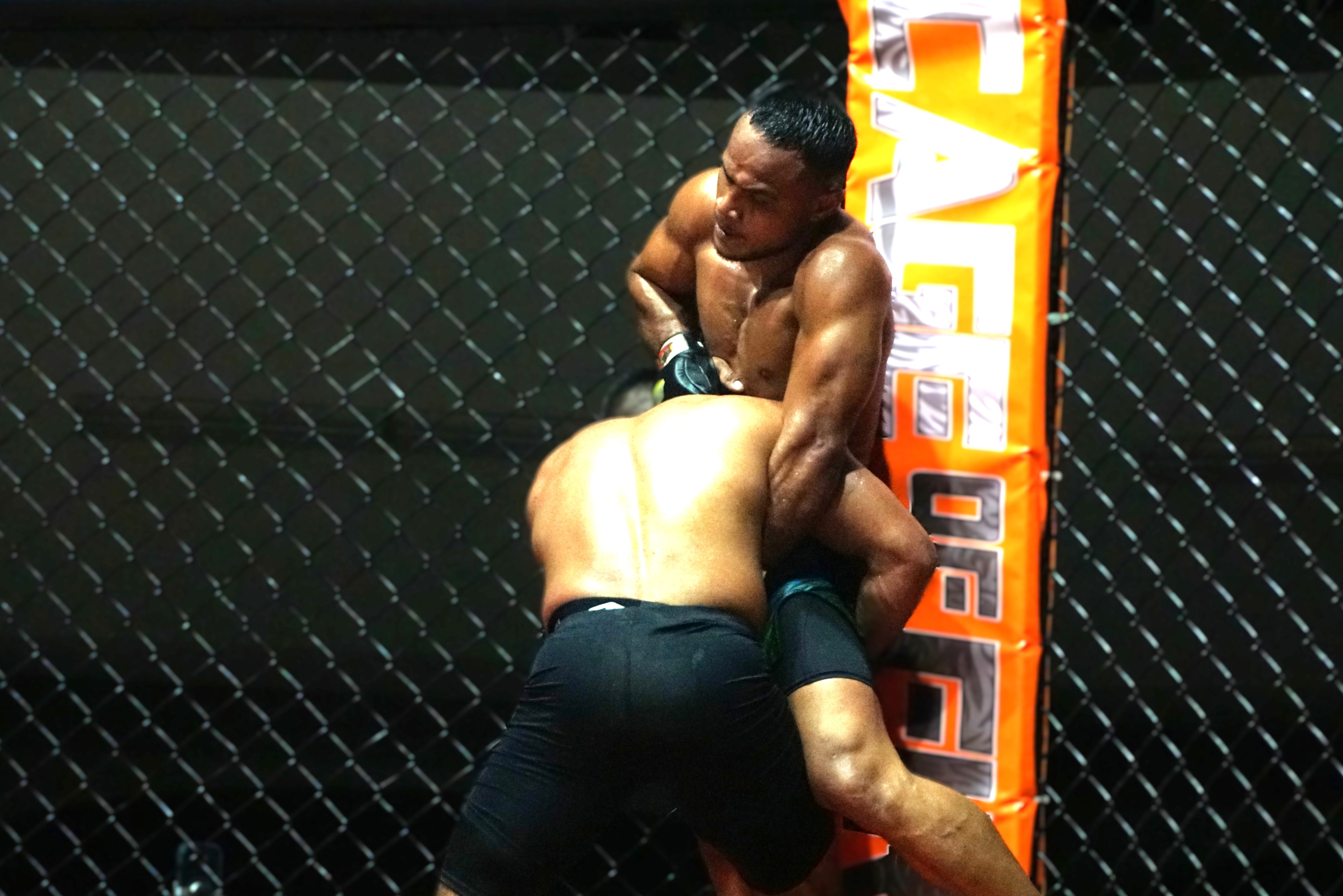 Derrick Rangamar of Saipan gets pinned to the cage as he attempts to escape the clutches of Keith Sablan of Guam during Cage of Fire’s main event at the Garapan Roundhouse on Saturday night. 