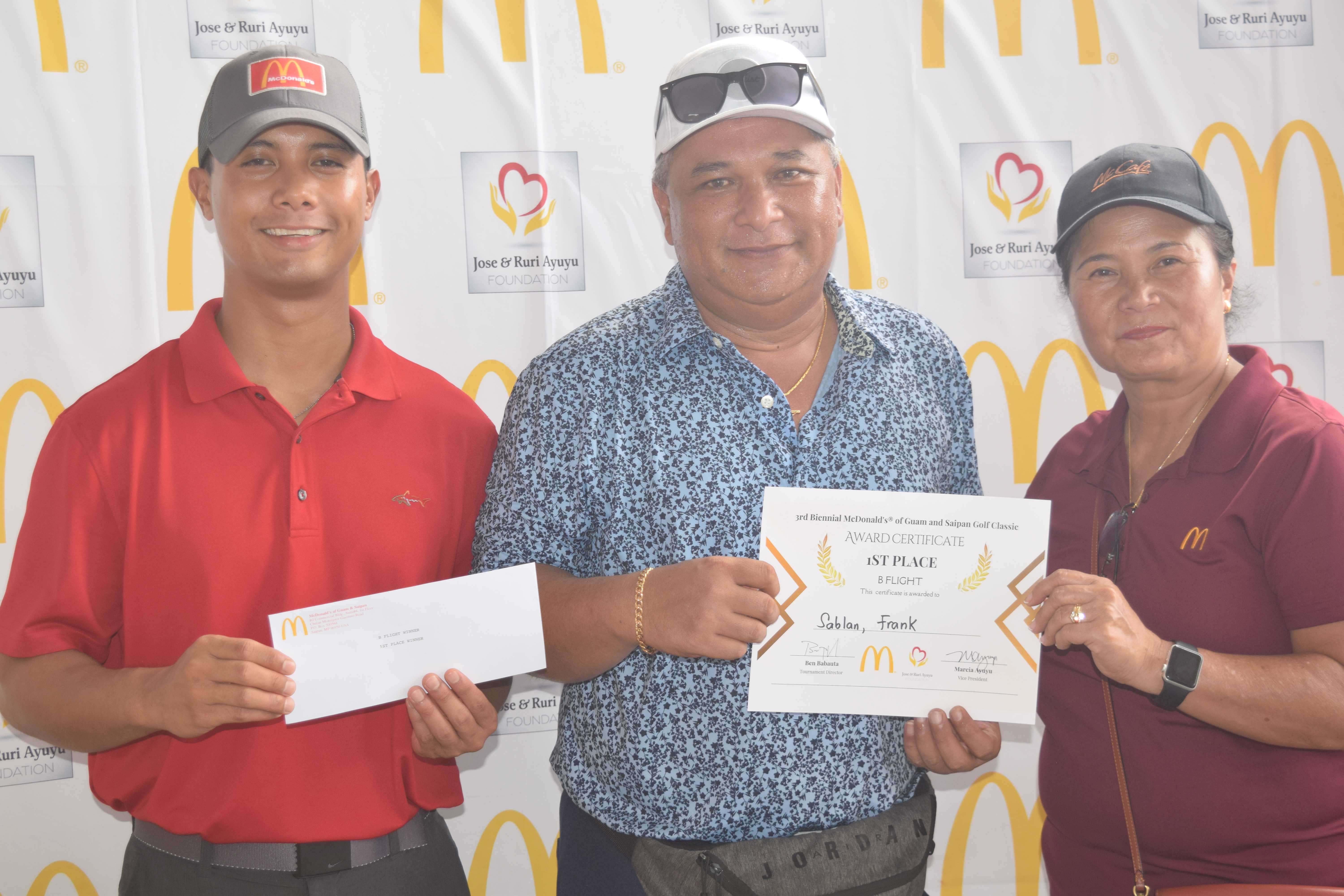 B Flight Champion Frank Sablan holds his prize as he poses for a photo with McDonald's of Guam and Saipan Vice President Joe E. Ayuyu Jr., left, and owner/operator Marcia Ayuyu.
