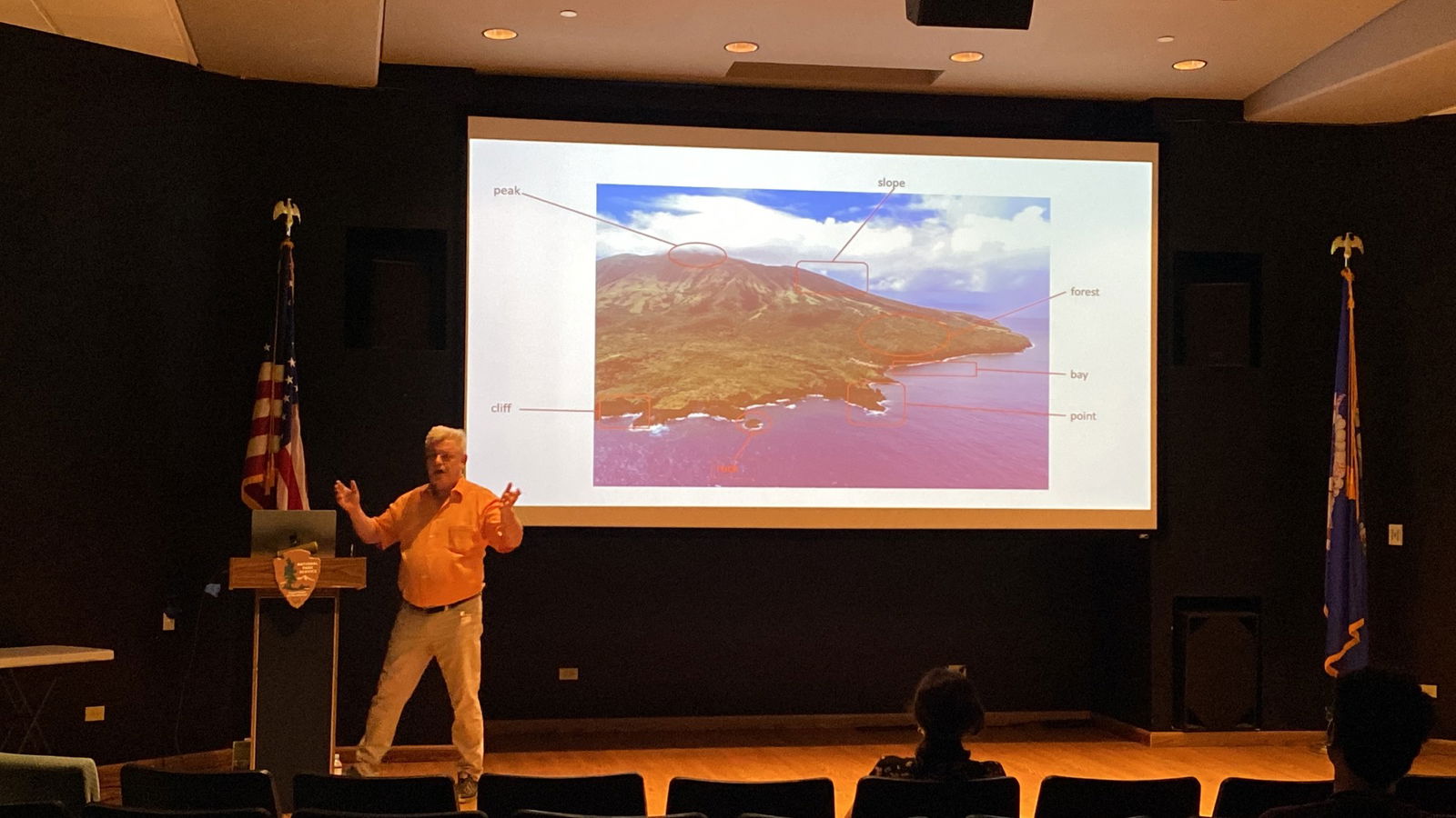 Dr. Thomas Stolz presents at the American Memorial Park theater on Tuesday, Dec. 10, 2024. Behind him is an enlarged photo of Alamagan.