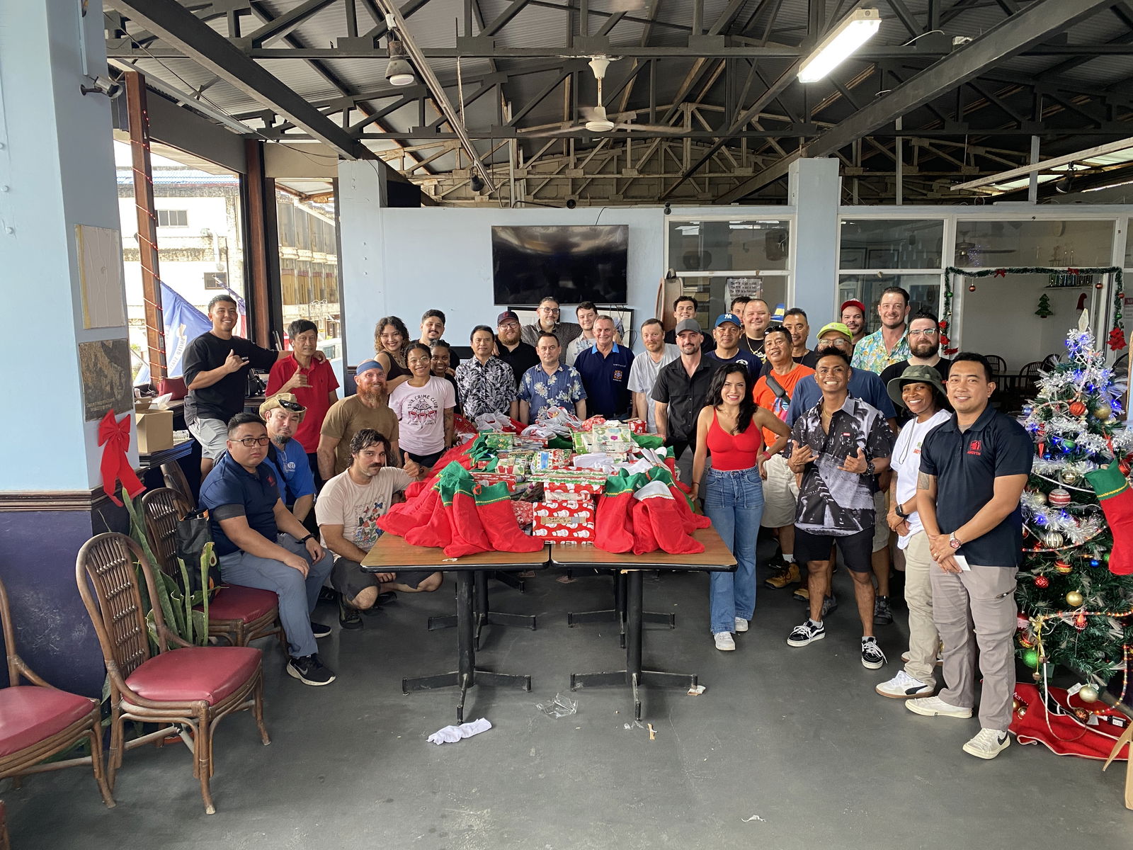  USNS Sisler and Watkins crewmembers pose for a group photo with the toys and other gifts they donated to Guma Esperansa.