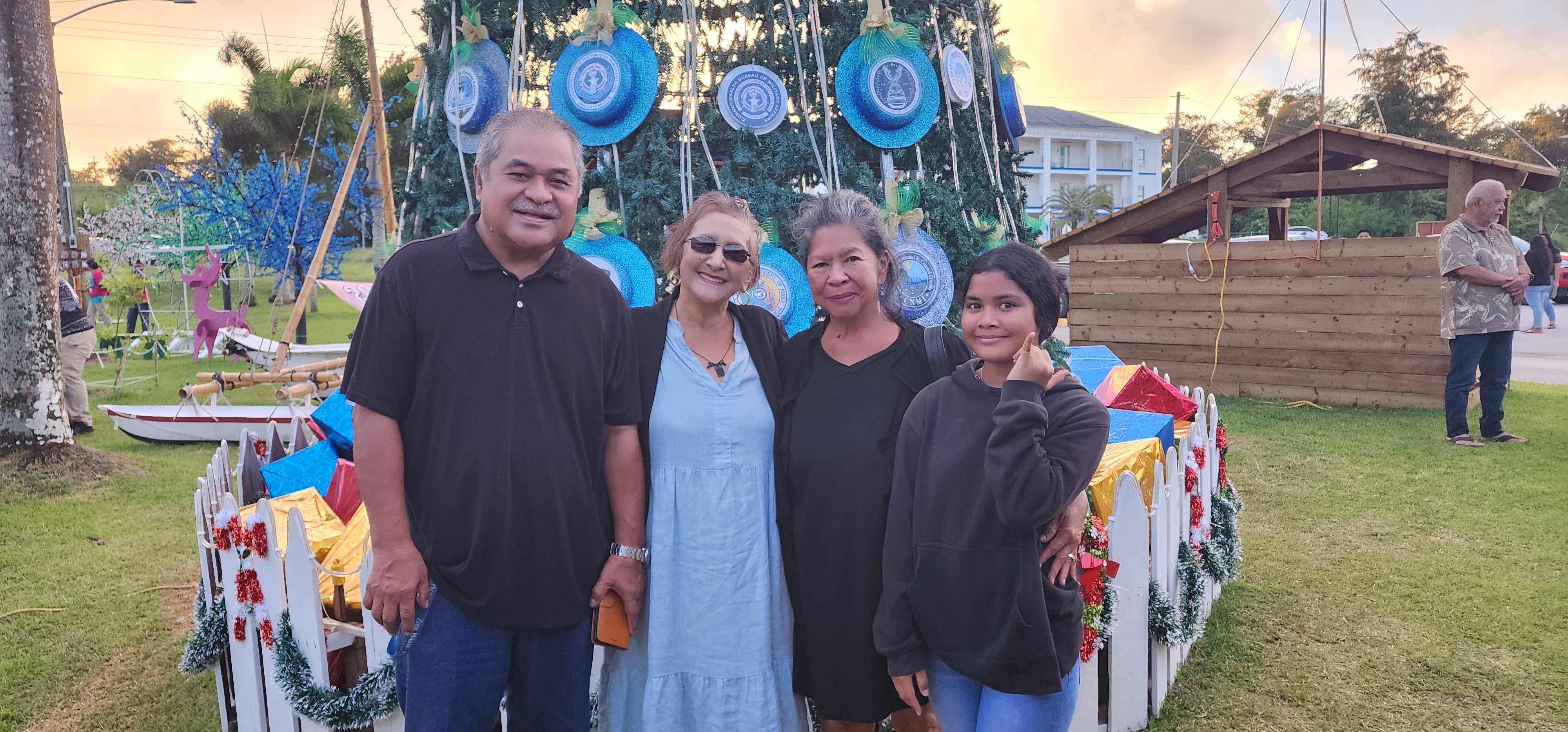 Department of Community and Cultural Affairs Secretary Frank Rabauliman, left, wife Marcie and grandaugher Ky, join First Lady Wella Palacios Foundation President Becky P. Cruz prior to the “Santa’s Sealand” Christmas lighting festivity on the grounds of the administration building on Capital Hill, Dec. 6, 2024.