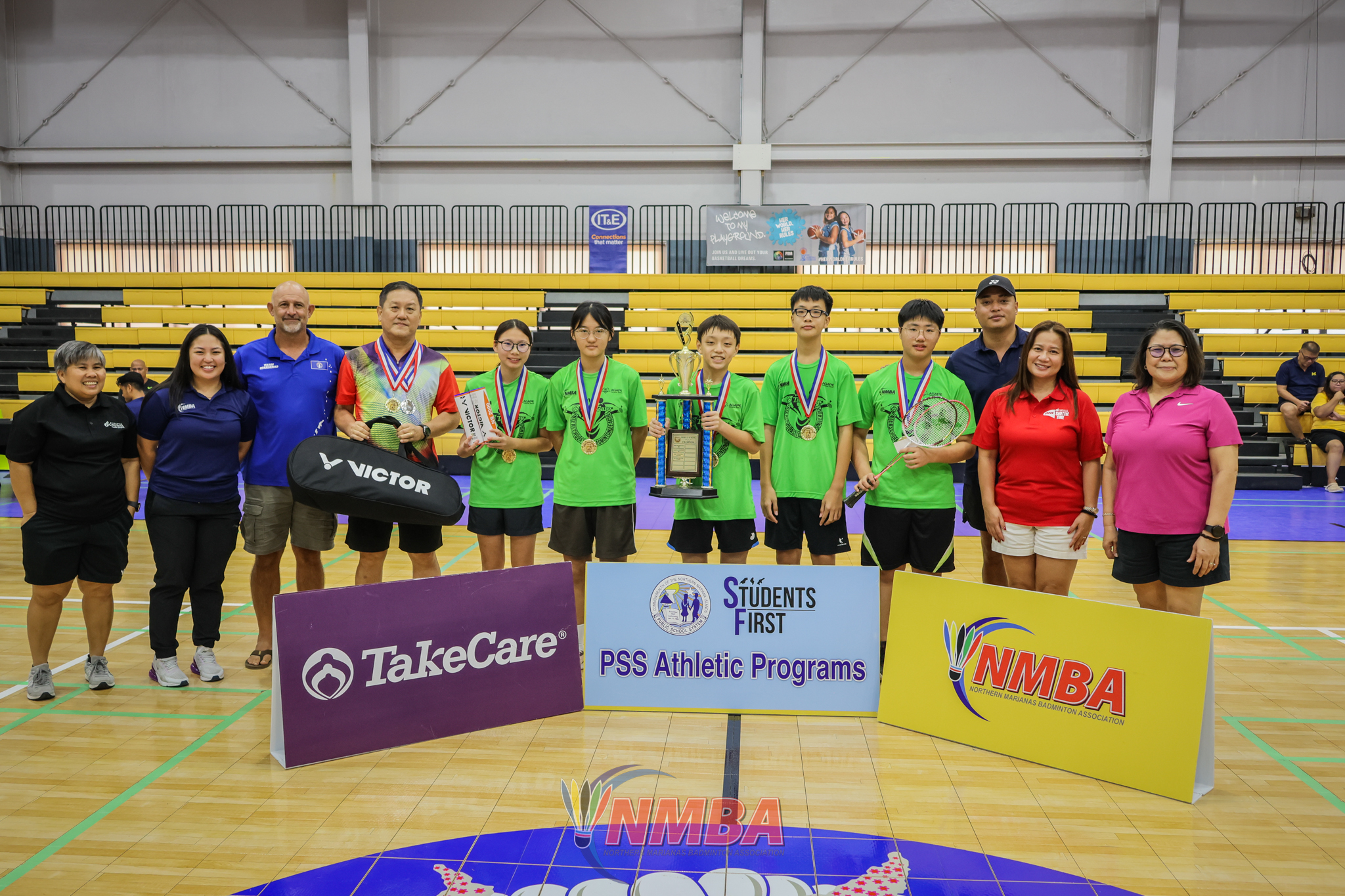 The Agape Christian School team 1 players pose with the co-ed middle school division championship trophy alongside NMBA and PSS officials during the awards ceremony of the PSS-NMBA Interscholastic Badminton League SY4-25 at the Ada gym on Saturday. 