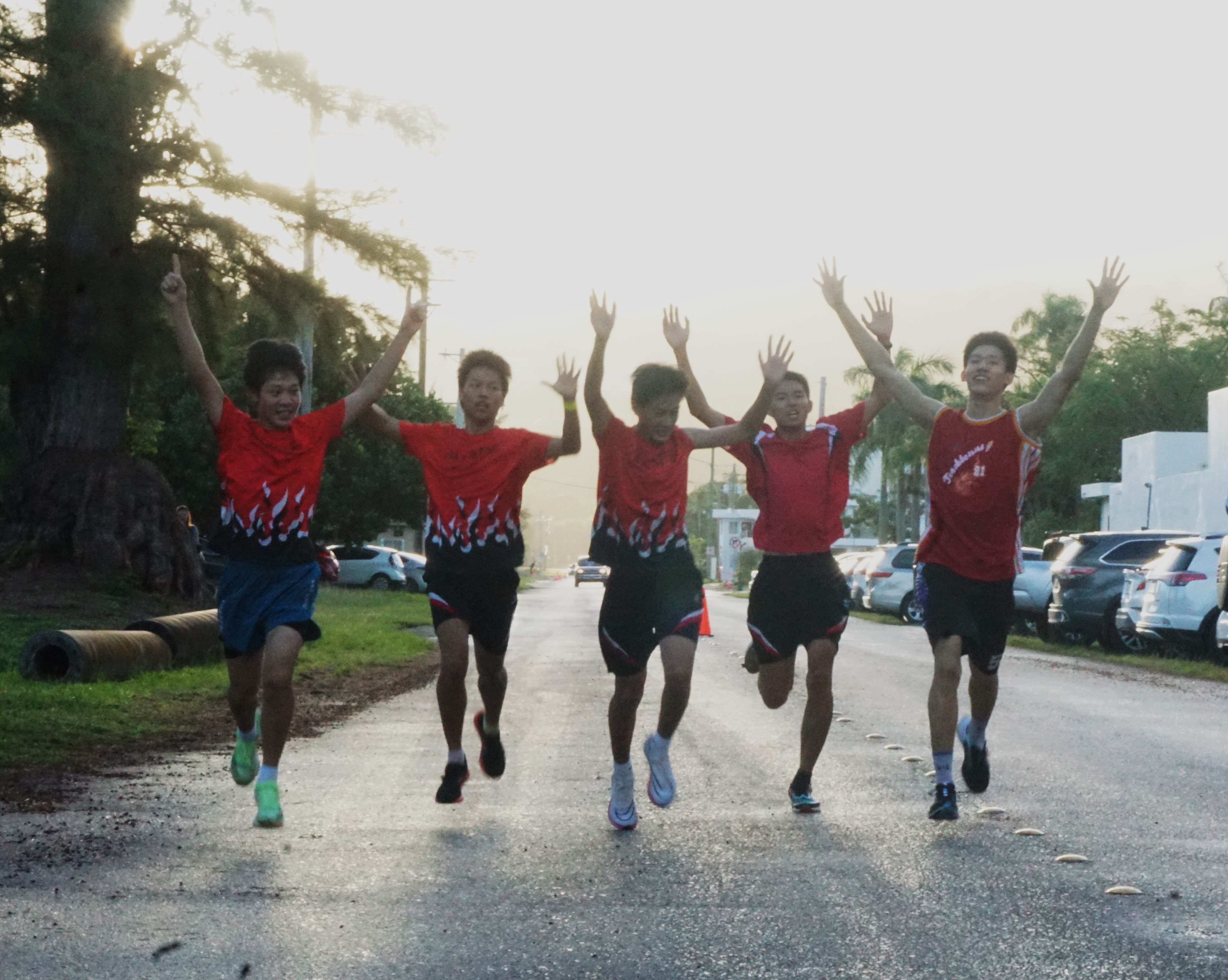 Agape Team 1 members raise their hands in celebration after finishing first and setting a new course record in Northern Marianas Athletics’ Annual Christmas Island Relay 2023 at Micro Beach. 