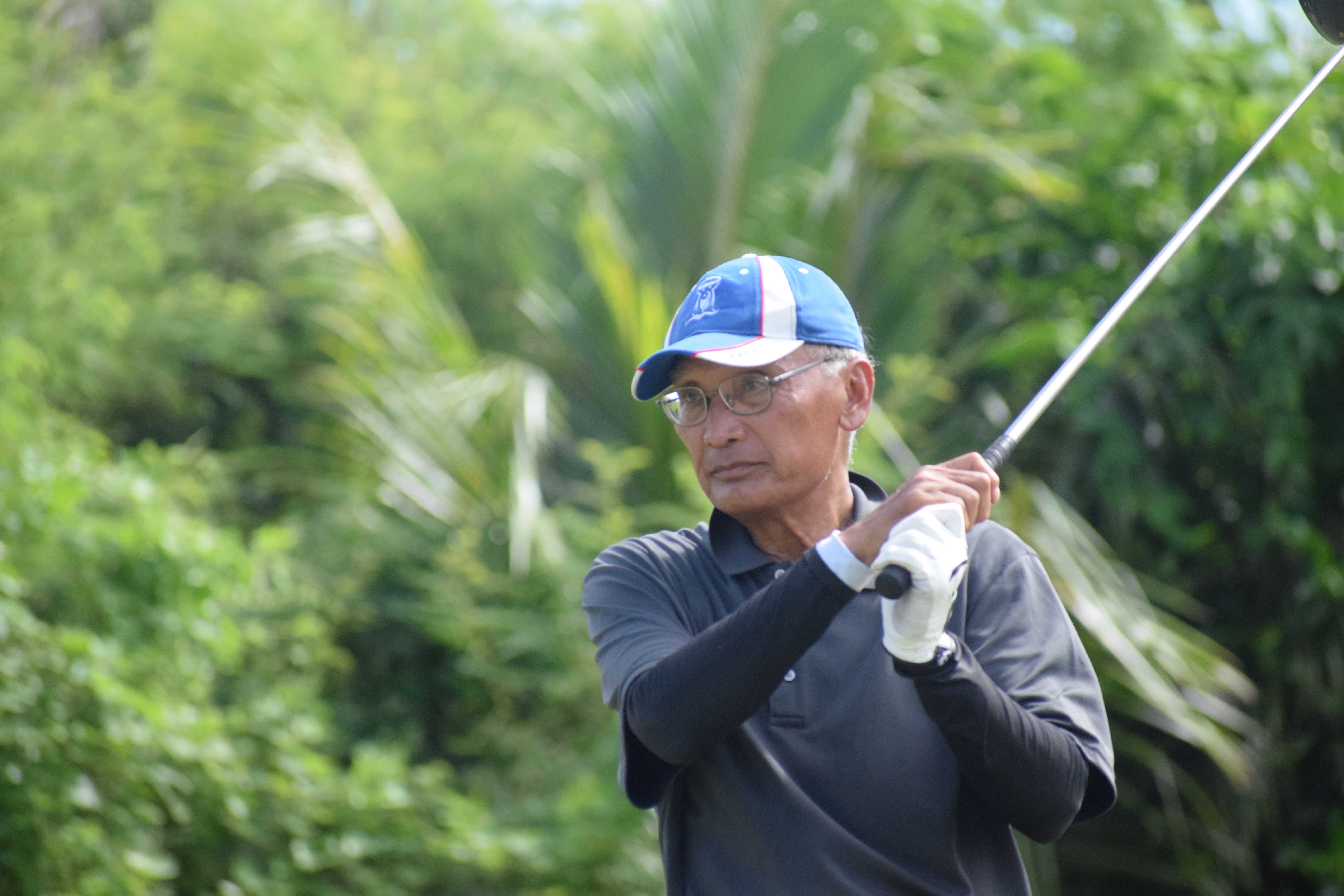 Former Gov. Juan Nekai Babauta watches the ball after teeing off.