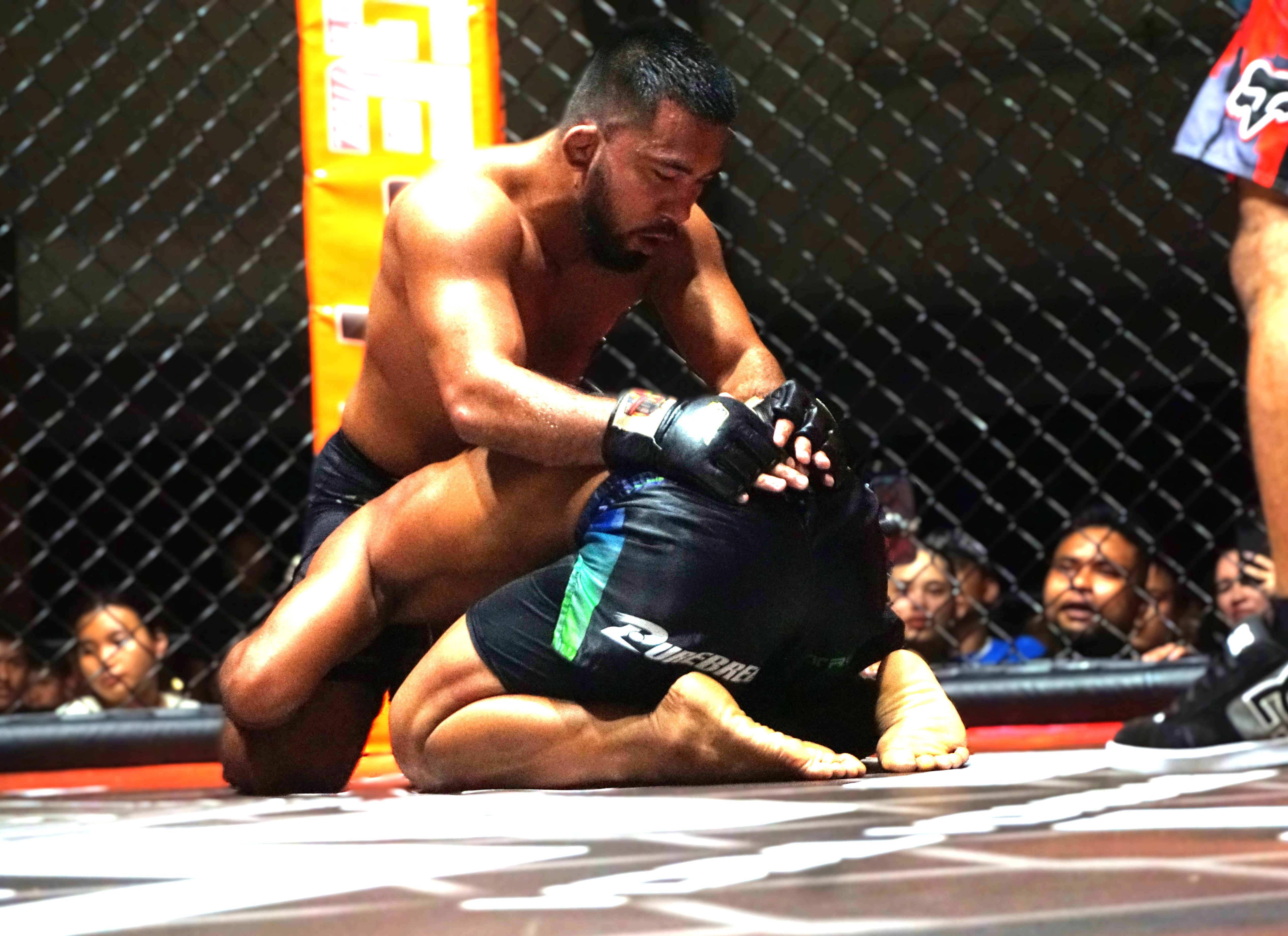 Keith Sablan of Guam goes to work on the ground against Derrick Rangamar of Saipan during the main event of Cage of Fire at the Garapan Roundhouse on Saturday night.
