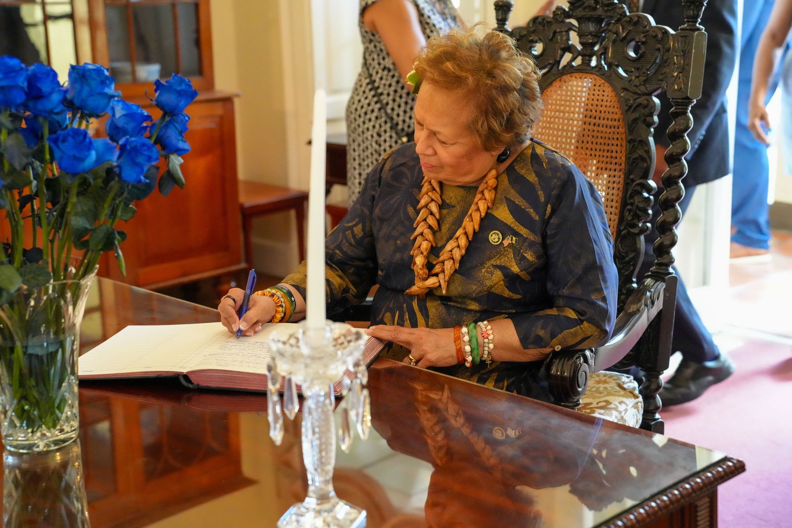 Congresswoman Amata signs the guest book for the ceremony in Barbados.