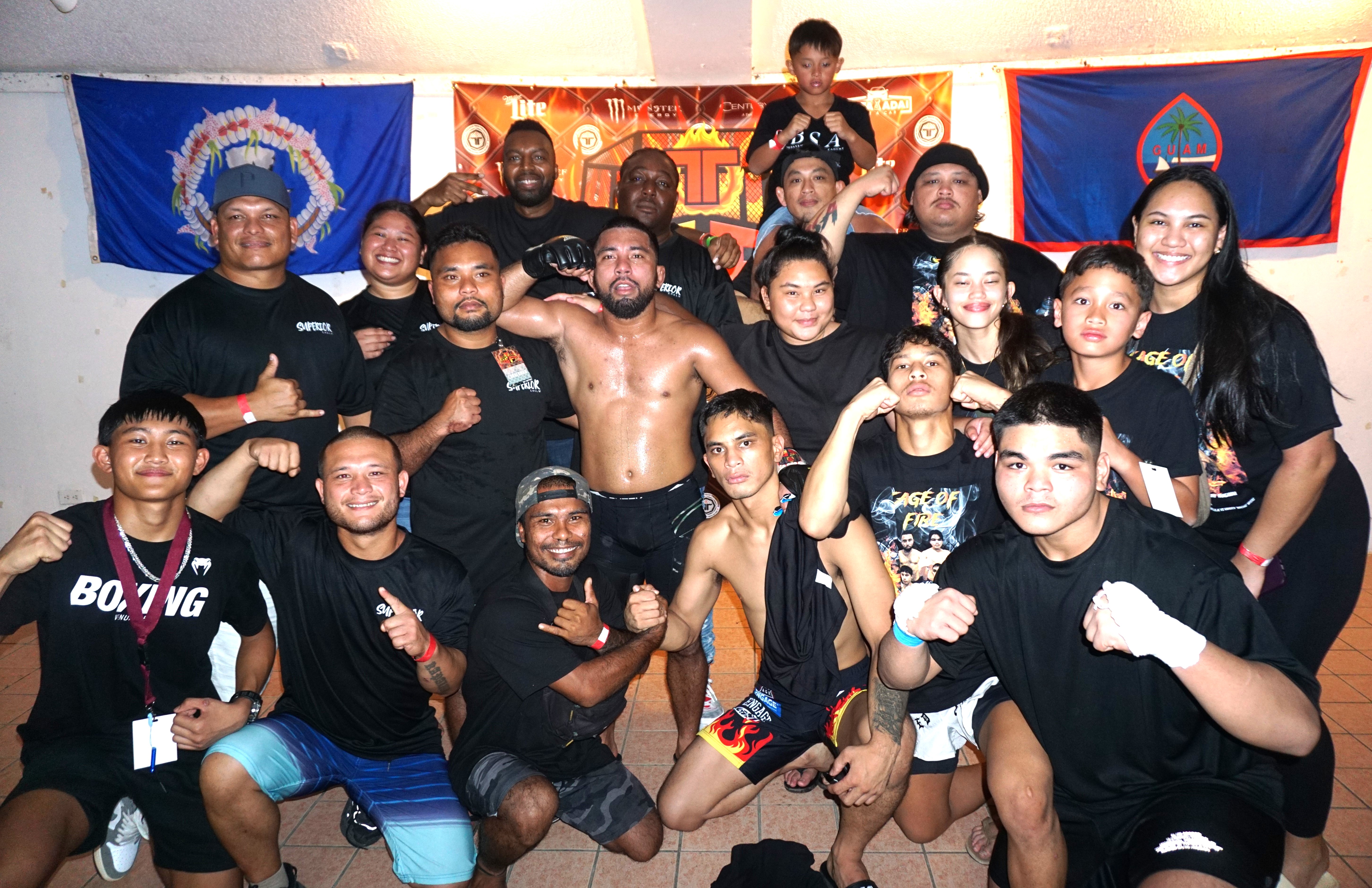 Guam’s Keith Sablan, center, poses with his family and the Benavente Striking Academy crew after winning Cage of Fire’s main event at the Garapan Roundhouse on Saturday night.