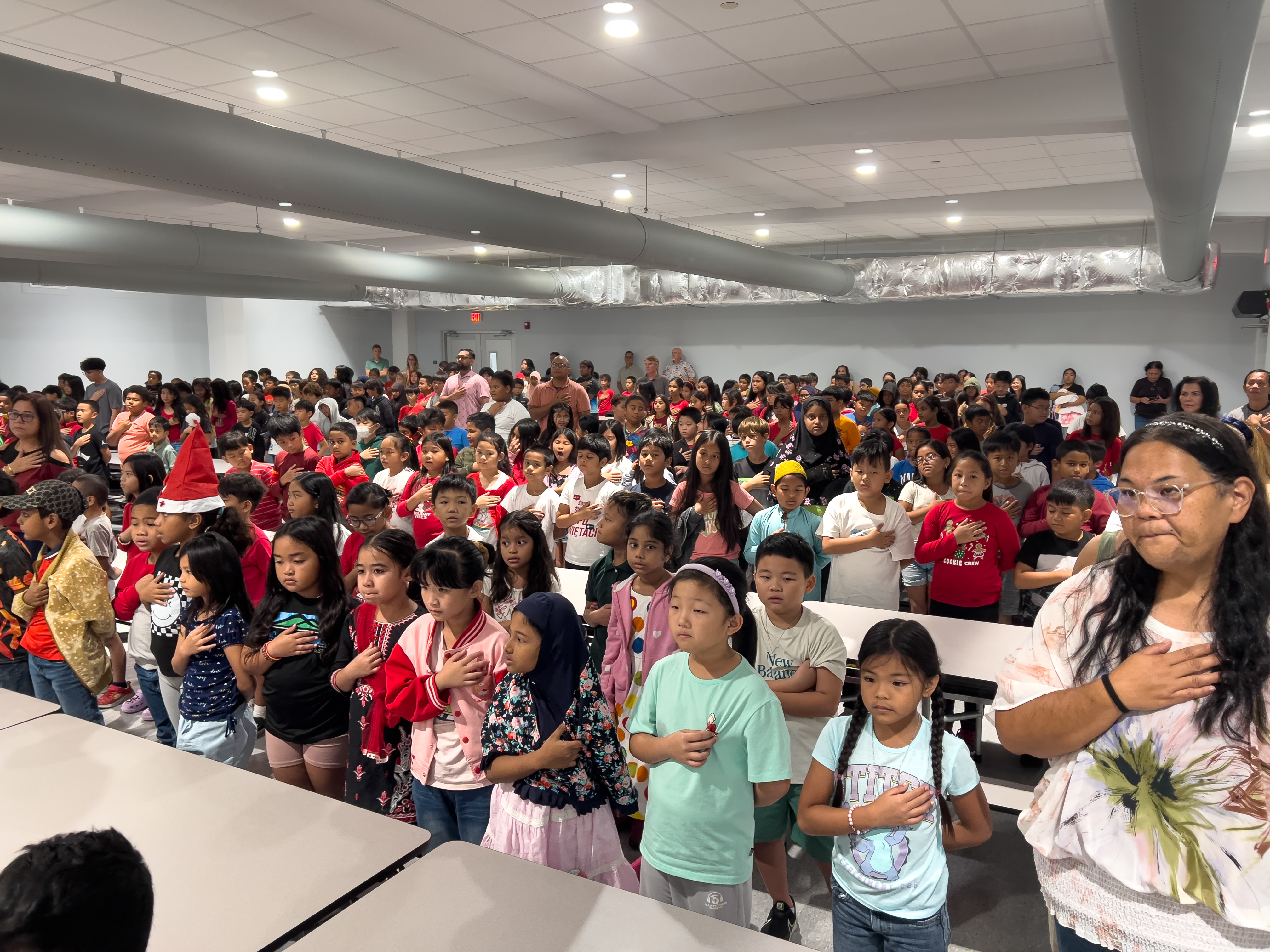 Garapan Elementary School students sing the national anthem in their newly constructed cafeteria.