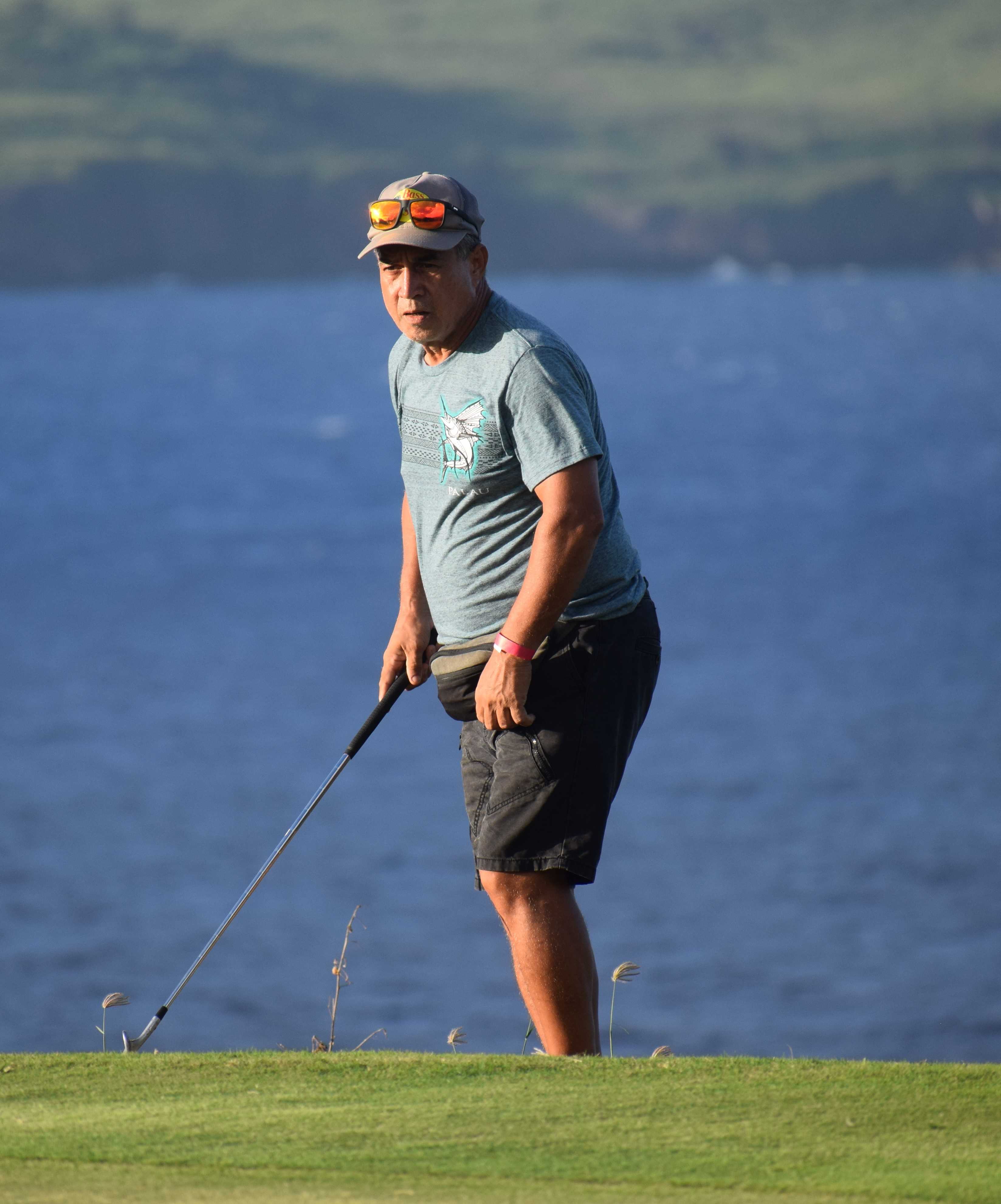 Rep.-elect Elian Rangamar looks on after chipping into the green.