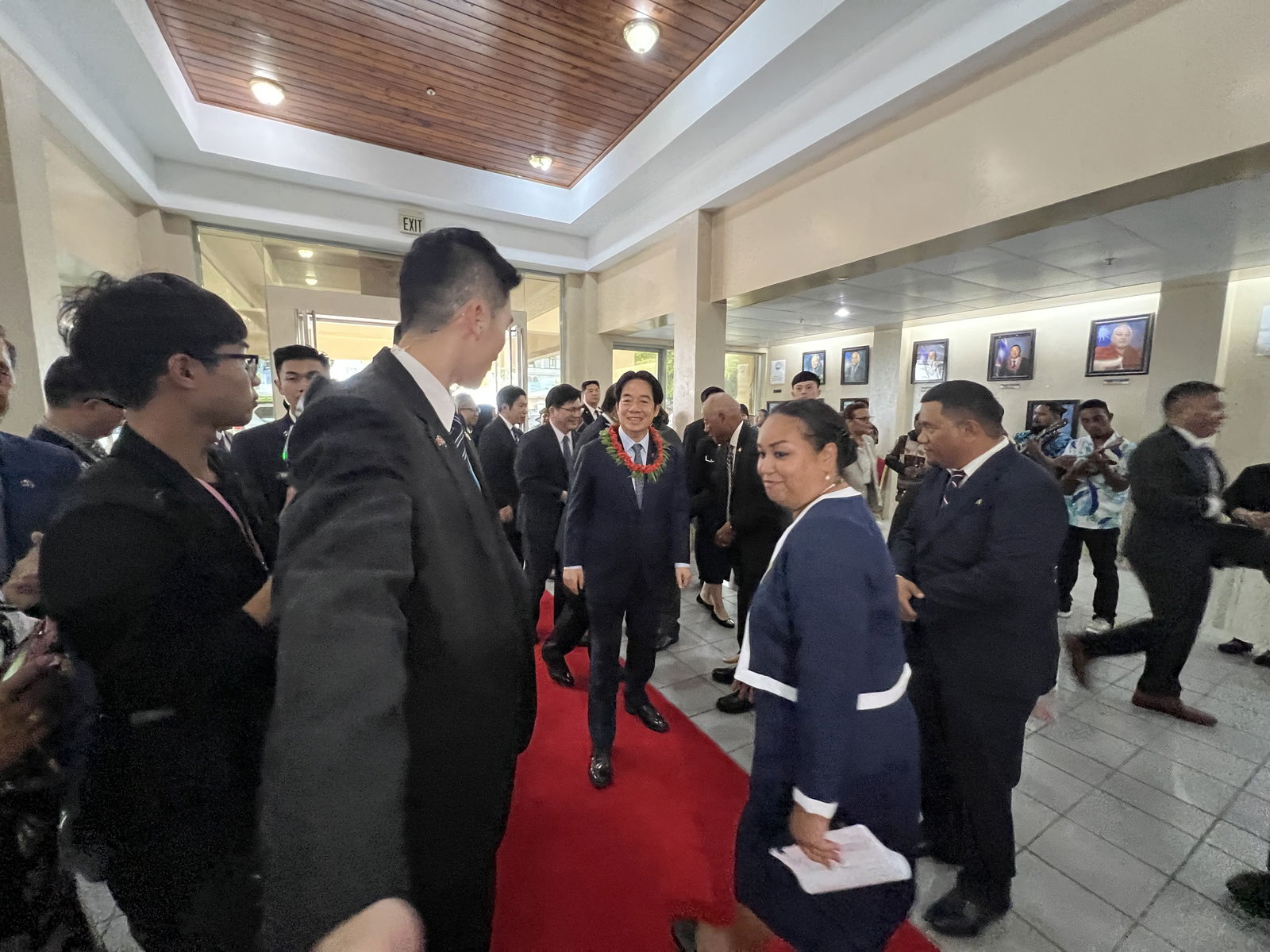 Taiwan President Lai Ching-te enters the Marshall Islands Nitijela (parliament) lobby before addressing the parliament and the nation Tuesday afternoon via live stream and government radio. He is being ushered in by Marshall Islands Foreign Affairs Protocol Chief Handelene Maddison, Parliament Assistant Clerk Carl Alik and Taiwan security personnel.