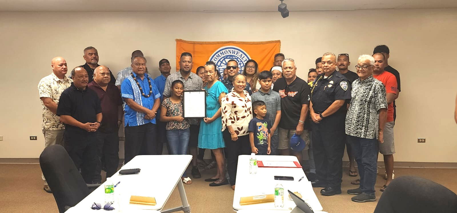 Jesusa Helgen, the wife of the late former Commonwealth Ports Authority Chief of Ports Police Pius Helgen, holds a framed copy of CPA Resolution 2024-6, as she poses for a photo with family members and CPA officials on Thursday at the Francisco C. Ada/Saipan International Airport’s Aircraft Rescue and Firefighting classroom.