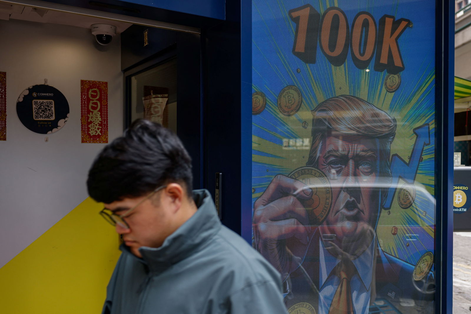 An illustration featuring President-elect Donald Trump holding Bitcoin is displayed outside a cryptocurrency exchange store after Bitcoin soars above $100,000, in Hong Kong, Dec. 5, 2024.