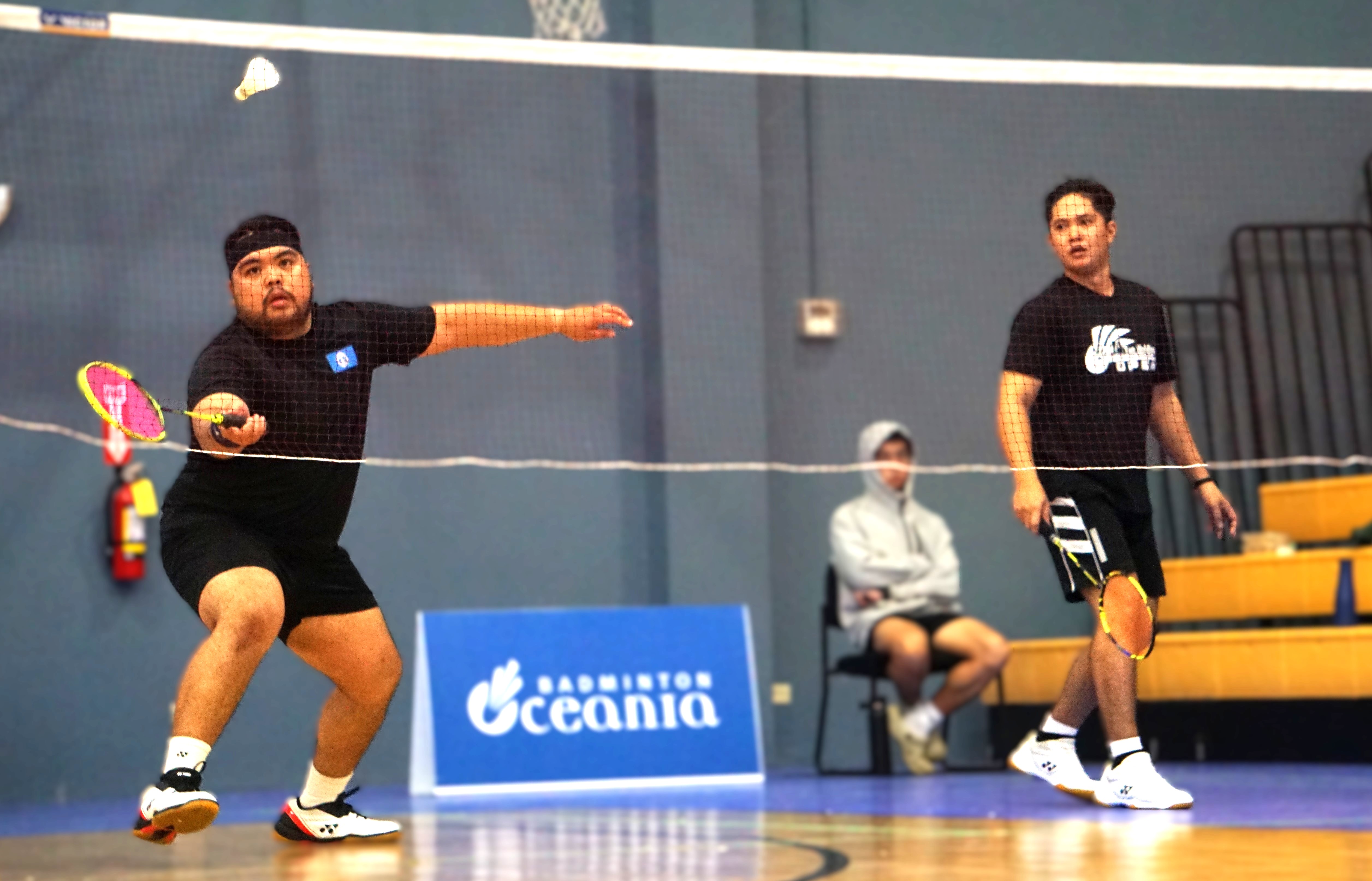 Jordan Pangilinan extends for the return as teammate Jomarie Azura looks on during the men’s doubles championship match in the open division of the NMI Badminton National Championships 2024 at the Ada gym on Saturday. 
