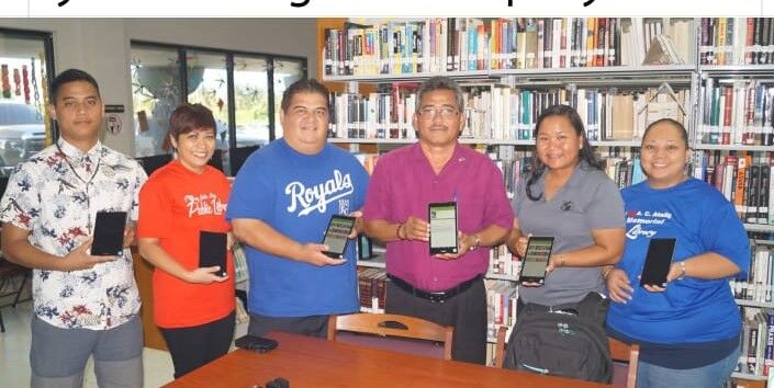 Former House Floor Leader George Norita Camacho, third left, and the late former Rota Mayor Efraim Atalig, third right, join Joeten-Kiyu Public Library Executive Director Erlinda Naputi, second right, and other library officials in presenting iPads for children at the Antonio Camacho Atalig Memorial Library on Rota on March 16, 2022. 