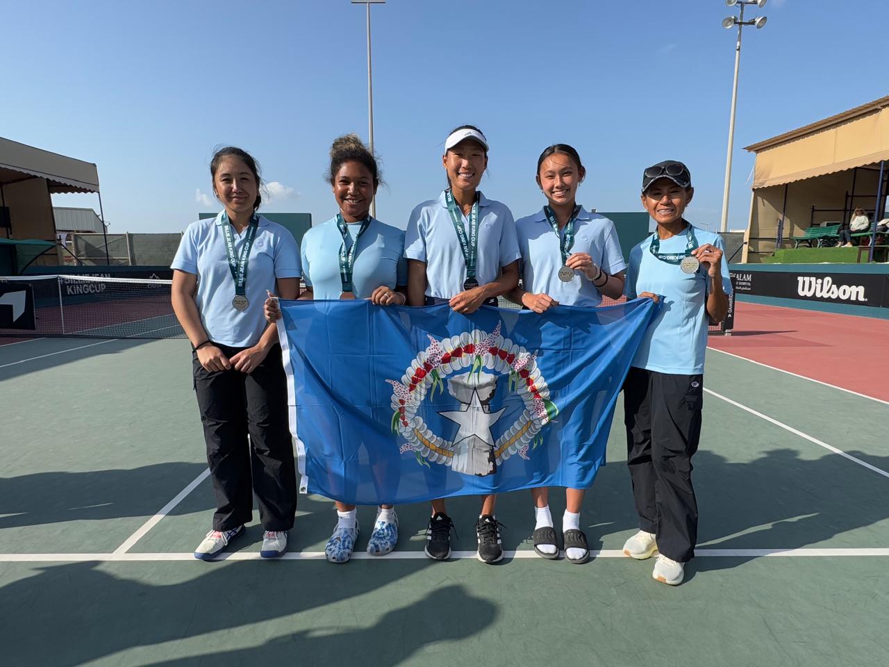 Team NMI's Isabel Heras, Asian Raulerson, Carol Lee and Hye Jin Elliot, with team captain Lydia Tan, pose with their promotional medals in the 2024 Billie Jean King Cup at the Bahrain Tennis Federation tennis courts in Isa Town, Bahrain.