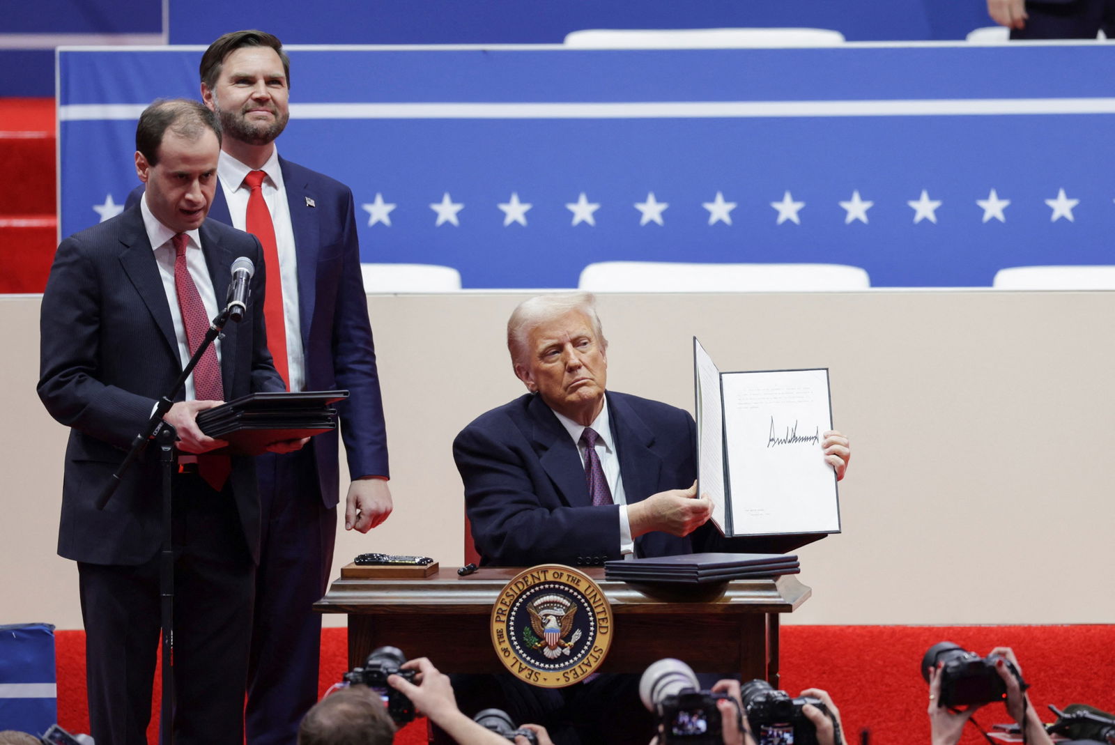 President Donald Trump shows a signed executive order as Vice President J.D. Vance looks on during a rally on the inauguration day of his second presidential term, inside Capital One, in Washington, D.C. Jan. 20, 2025.
