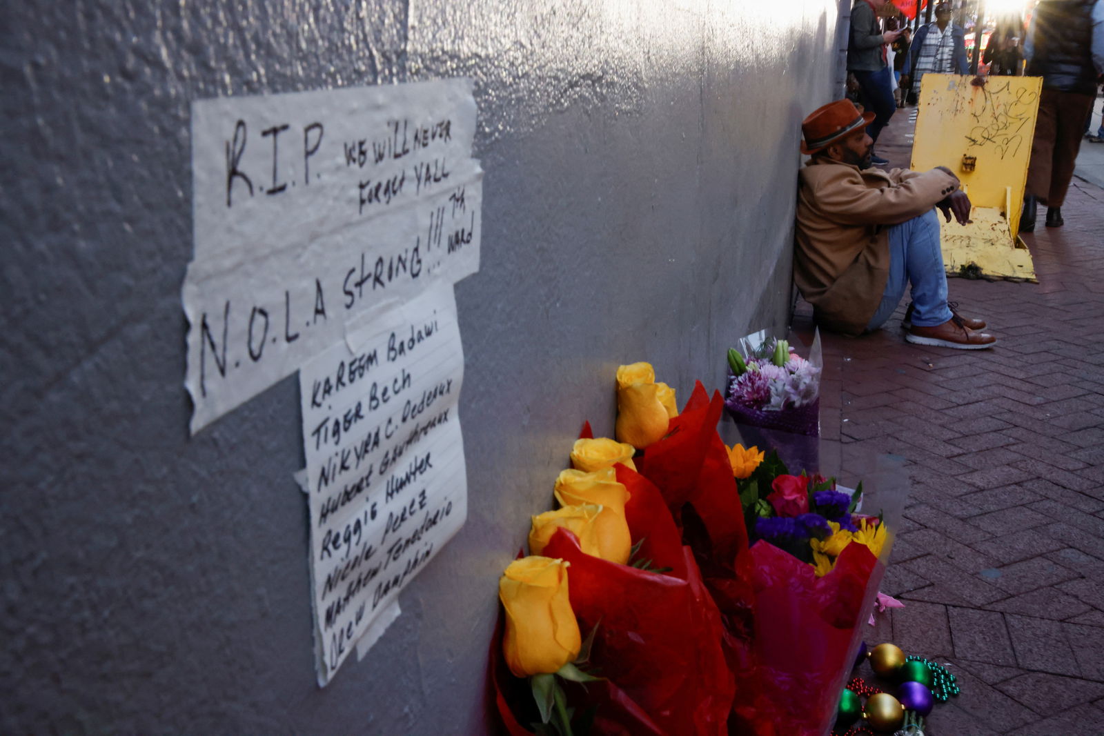 A person sits near a makeshift memorial, after people were killed by a man driving a truck in an attack during New Year's celebrations, in New Orleans, Louisiana, Jan. 2, 2025.