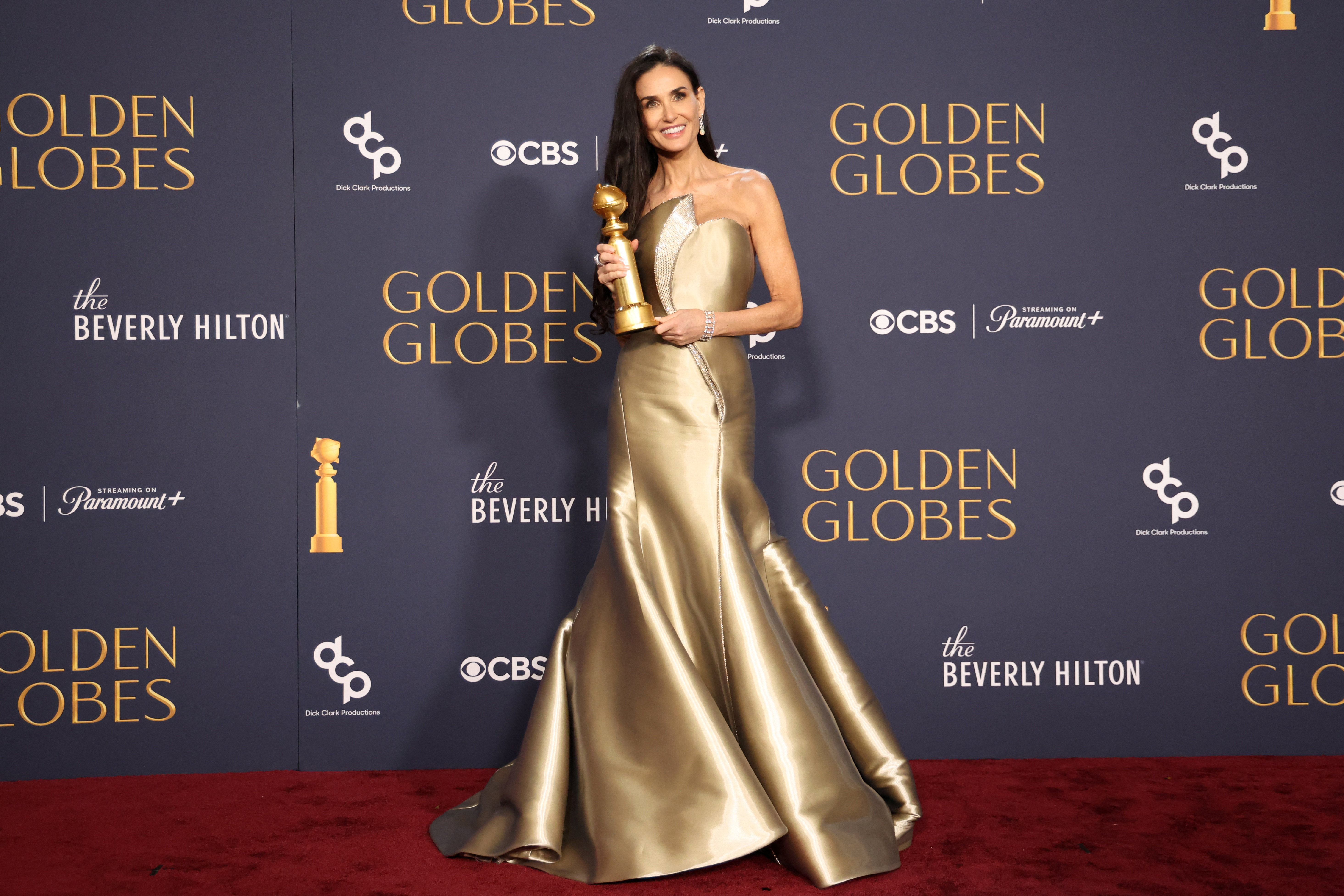 Demi Moore poses with the award for Best Performance by an Actress in a Motion Picture.