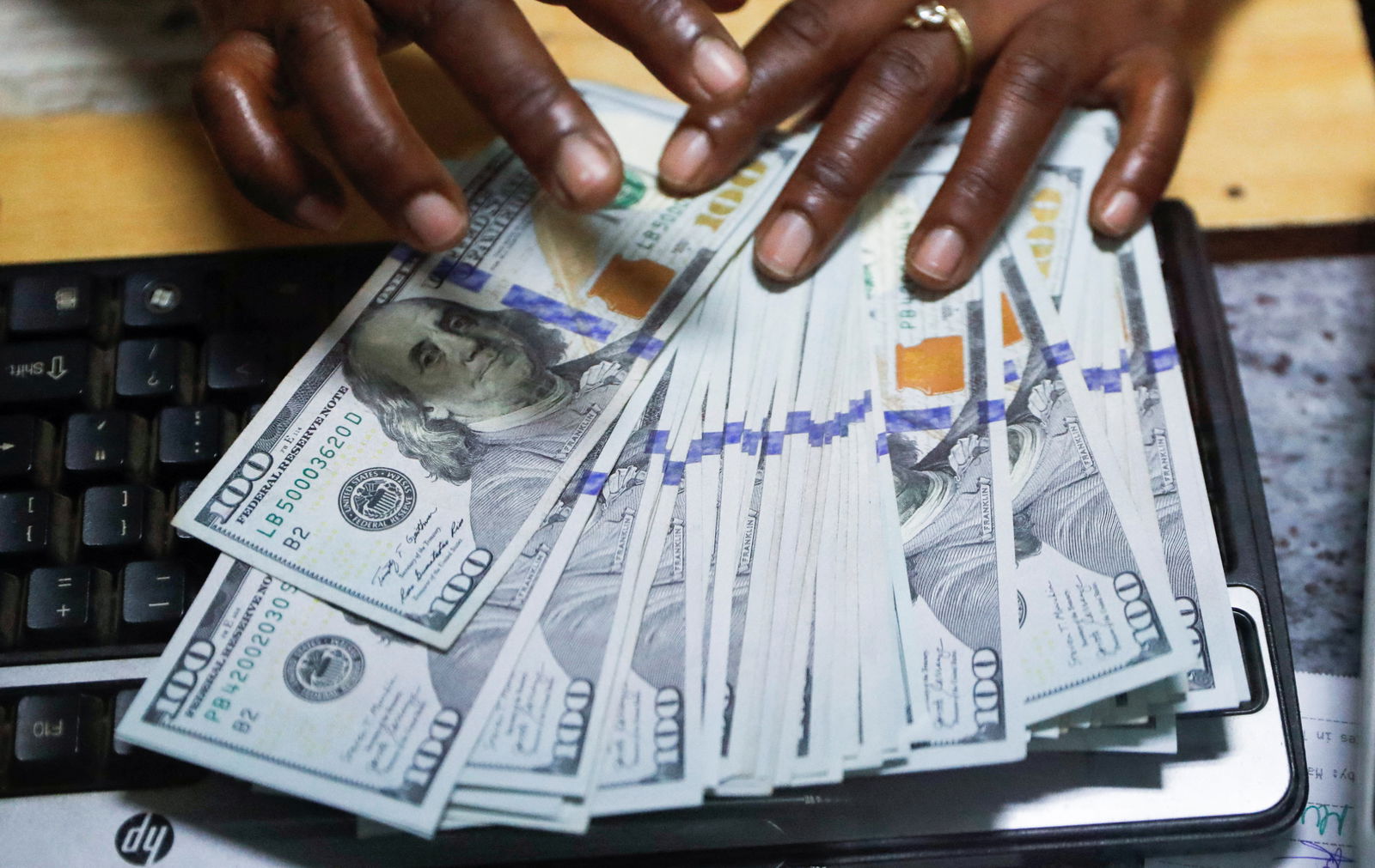 A teller sorts U.S. dollar banknotes inside the cashier's booth at a forex exchange bureau in downtown Nairobi, Kenya, Feb. 16, 2024.