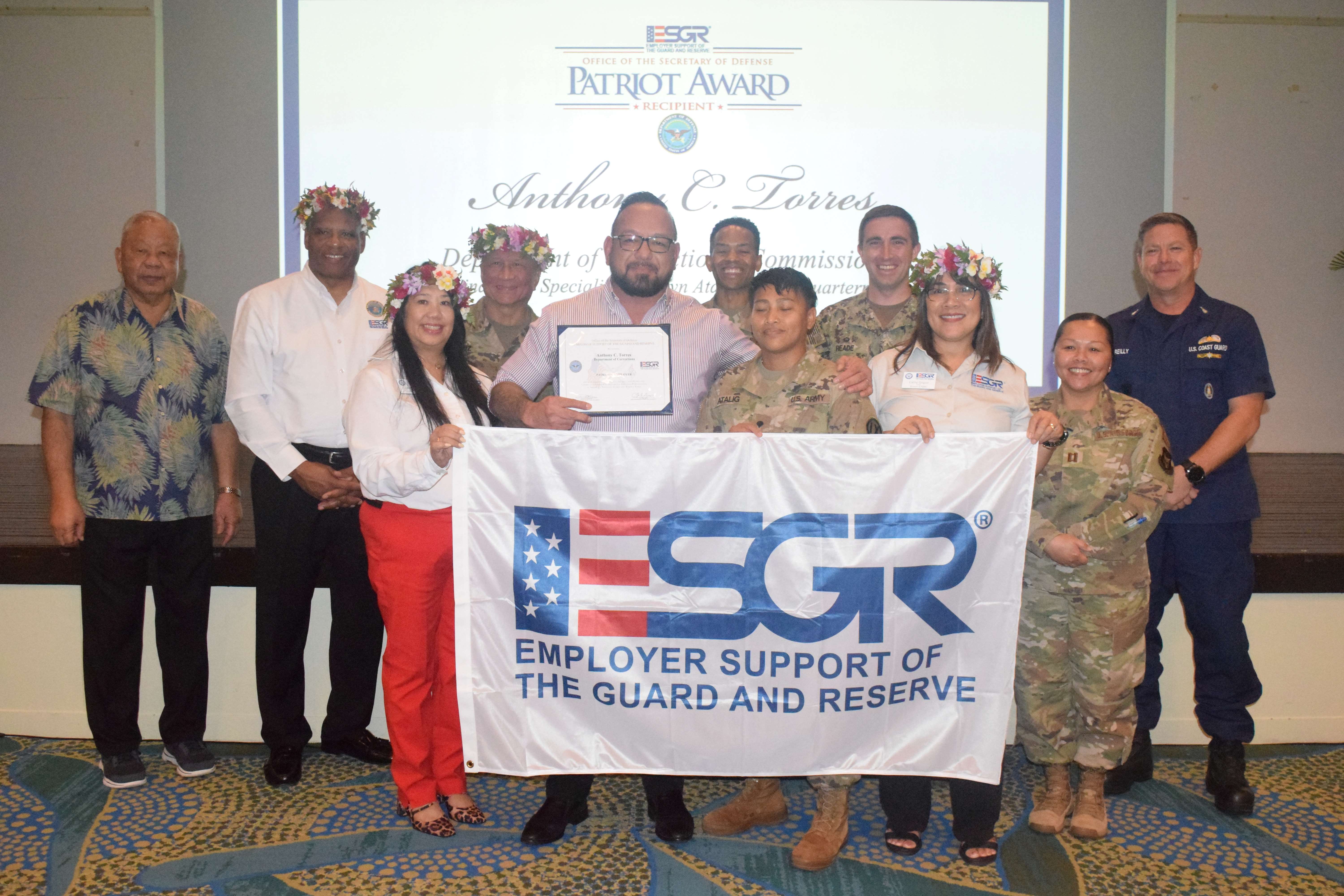 Department of Corrections Commissioner Anthony C. Torres holds his Patriot Award.