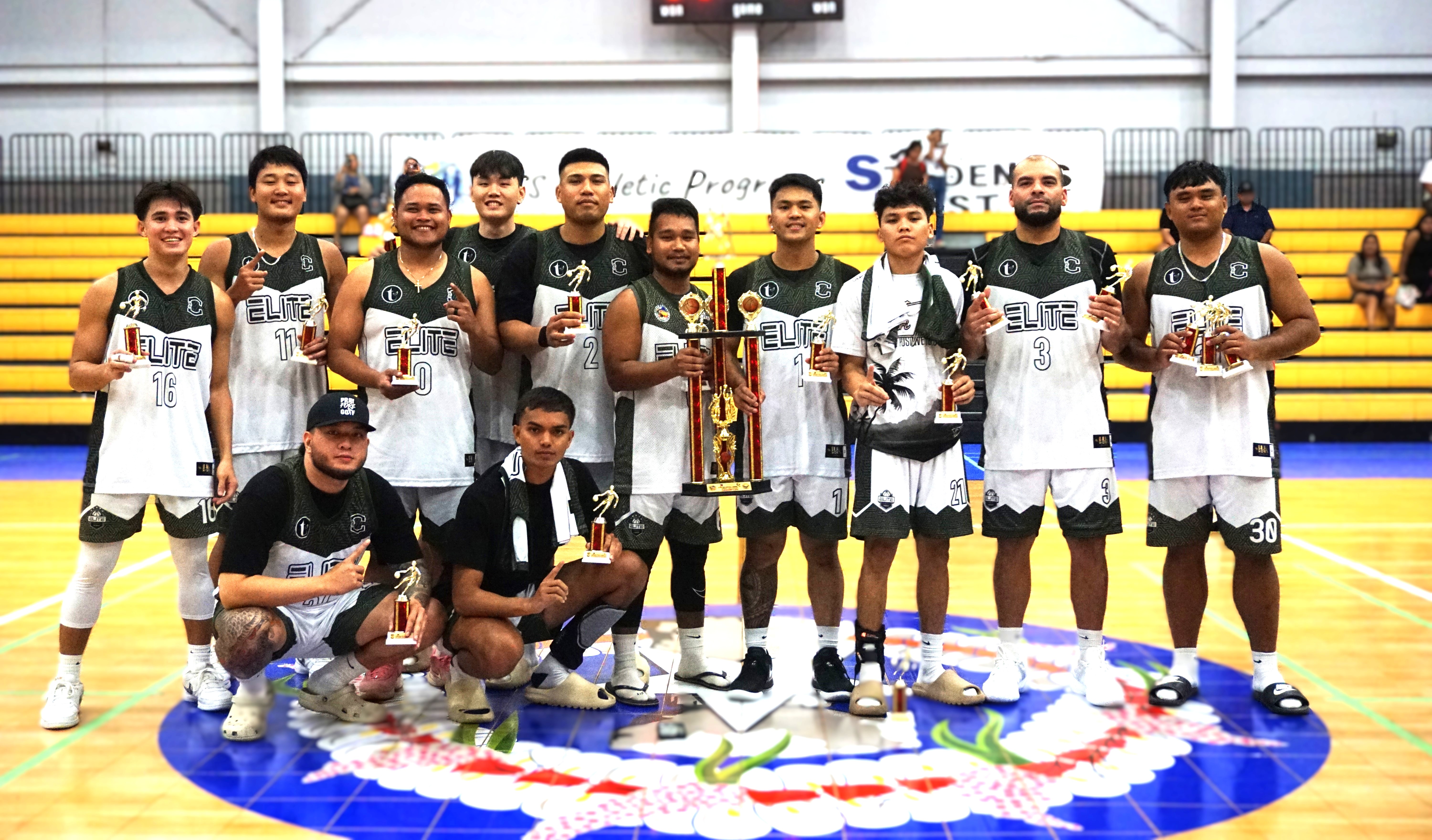 Team Elite players pose with the open division championship trophy during the awards ceremony of the 2nd Saipan Magalahi Eagles Club-Saipan MagaHaga Lady Eagles Group Basketball Tournament at the Ada gym on Sunday night.
