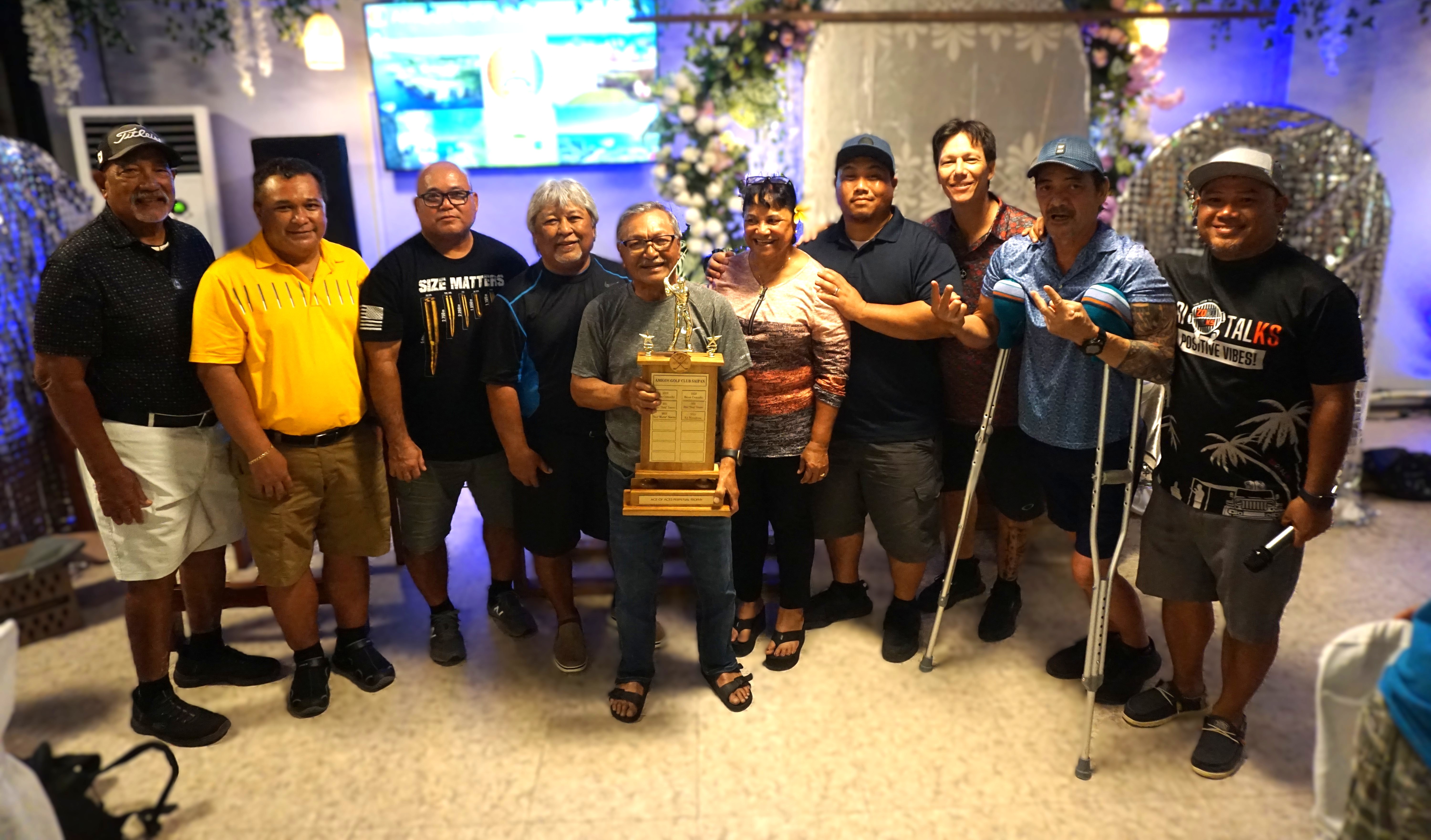 Ed Manglona poses with the Ace of Aces perpetual trophy alongside the rest of the monthly ace winners for a group photo during the annual awards banquet for the 2024 season of the Amigos Golf Club at Pepoy's Cafe & Restaurant on Friday.