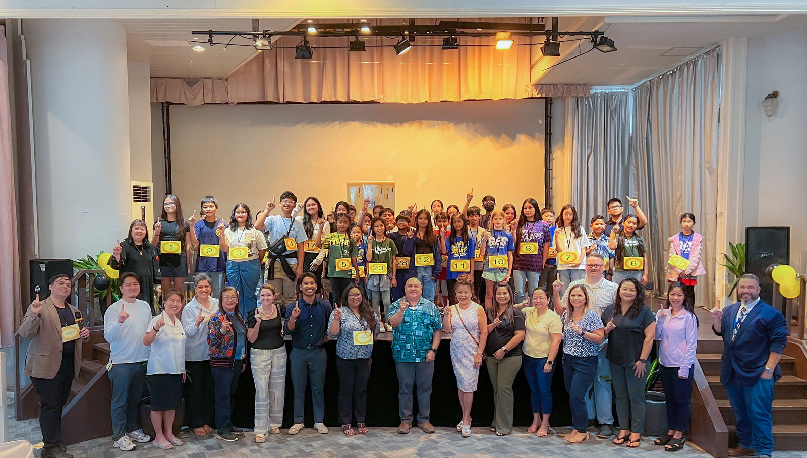 The CNMI’s best spellers from public and private schools gather for a group photo during the Public School System’s Spelling Bee at Grandvrio Resort Saipan’s Fiesta Hall on Jan. 22, 2025. Alleena Villaluz, an eighth grader at Saipan International School, is this year’s best speller. Joining them on stage are Commissioner of Education Dr. Lawrence F. Camacho, Senior Director for Instructional Services Dr. Rizalina G. Liwag, competition pronouncer Vinnie Orsini, PSS Social Studies Program Manager, and competition judges Instructional Technology and Distance Education Program Director Dr. Lorraine Catienza, English Learners Program Manager Charles Huston III, and Saipan Southern High School educator Kadmiel Rey, as well as school administrators from Saipan, Tinian, and Rota.  PSS photo