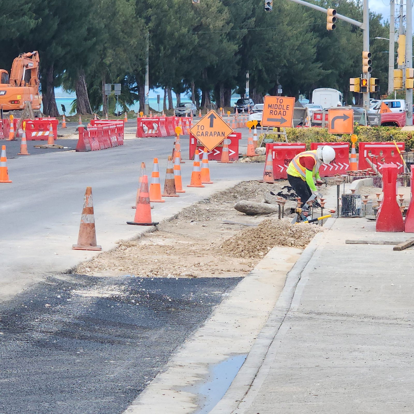 A construction laborer works on a sidewalk at the corner of Beach Road and Msgr. Guerrero Road in San Jose on Thursday.