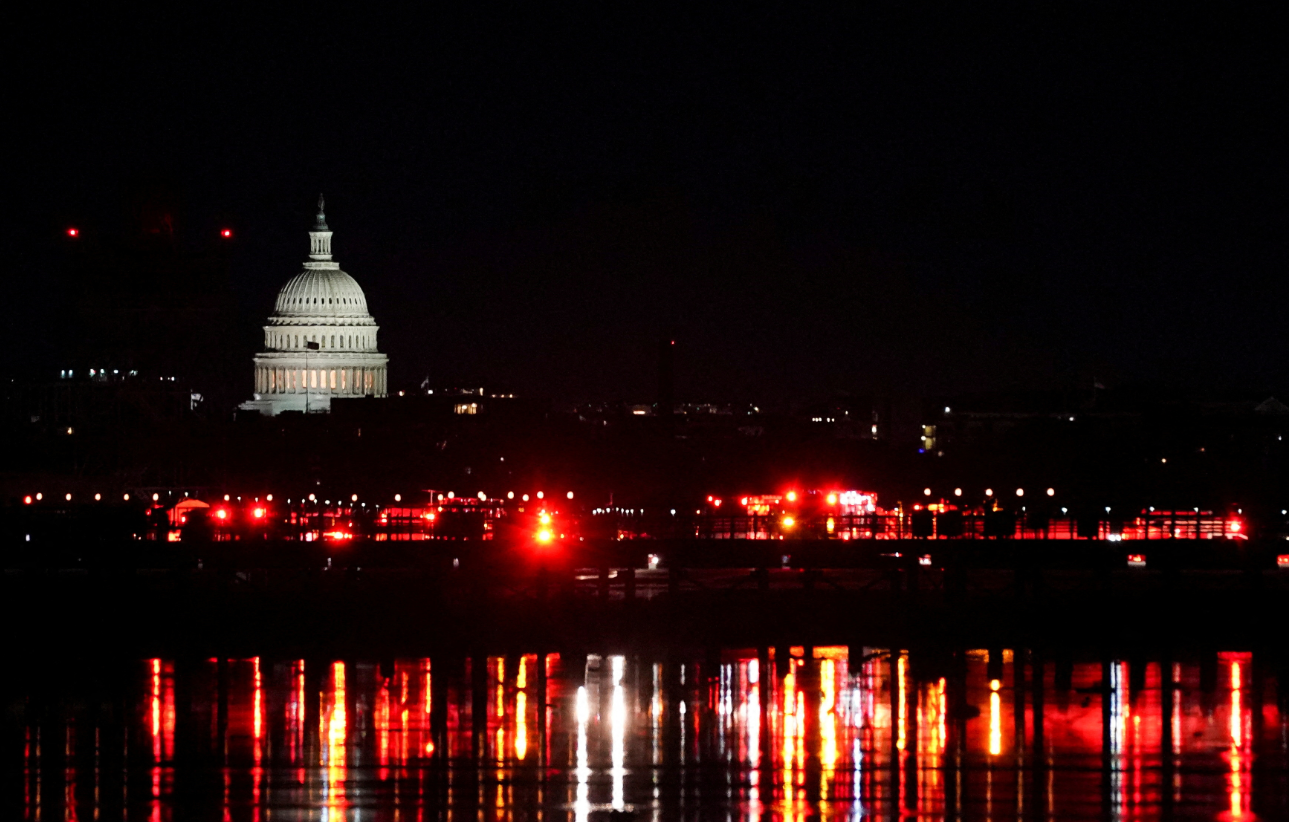 Emergency personnel work near the site of the crash, with the U.S. Capitol in the background, after American Eagle flight 5342 collided with a Black Hawk helicopter while approaching Reagan Washington National Airport and crashed in the Potomac River, Jan. 30, 2025. 