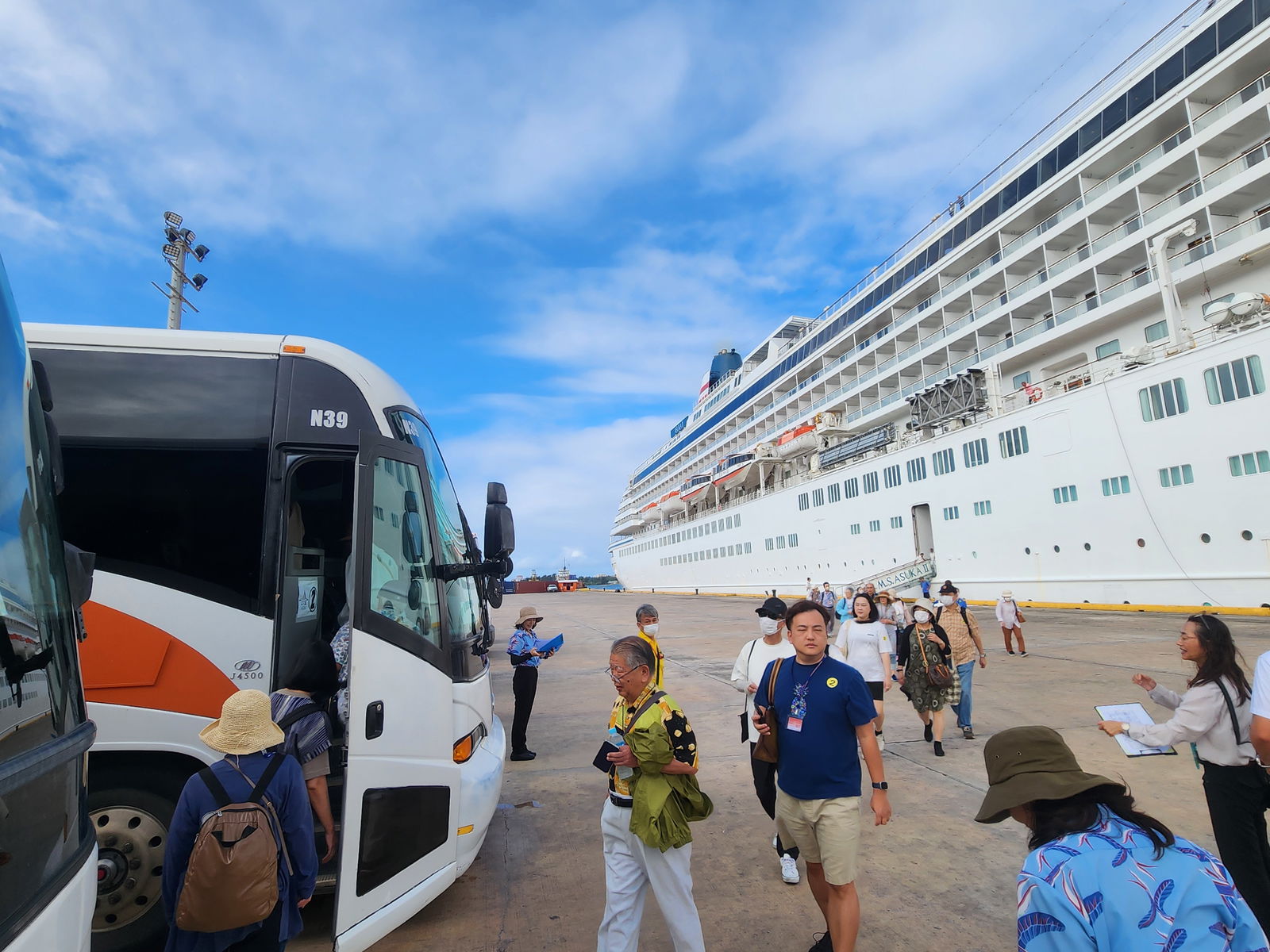 Asuka II passengers make their way to Pacific Development Inc. buses for an island tour on Tuesday morning, Dec. 31, 2024.