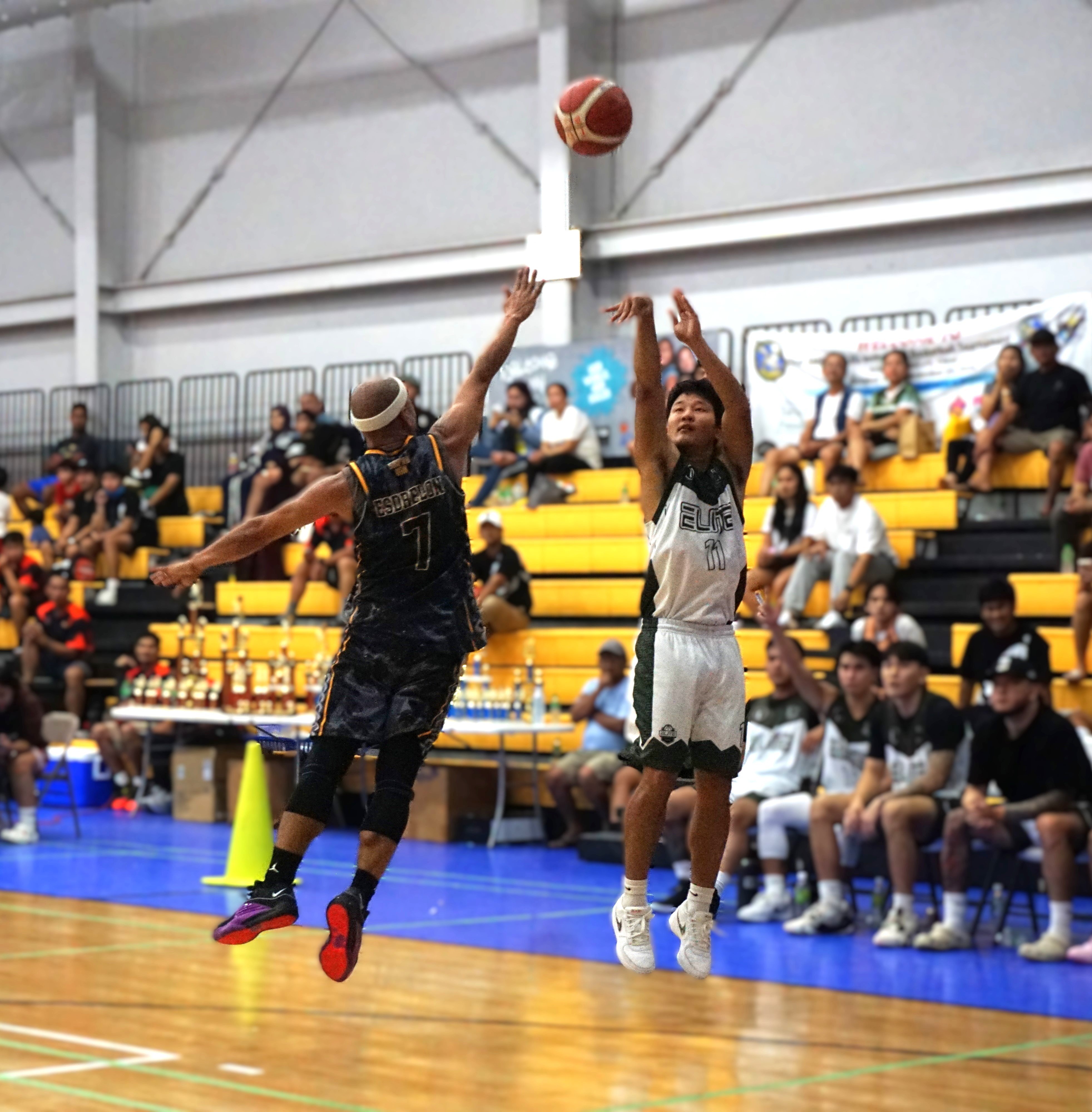 Elite’s Coby Santos pulls up for the three-point shot over Unity Trade’s Elmer Esdrelon during the championship game in the open division of the 2nd Saipan Magalahi Eagles Club-Saipan MagaHaga Lady Eagles Group Basketball Tournament at the Ada gym on Sunday night.