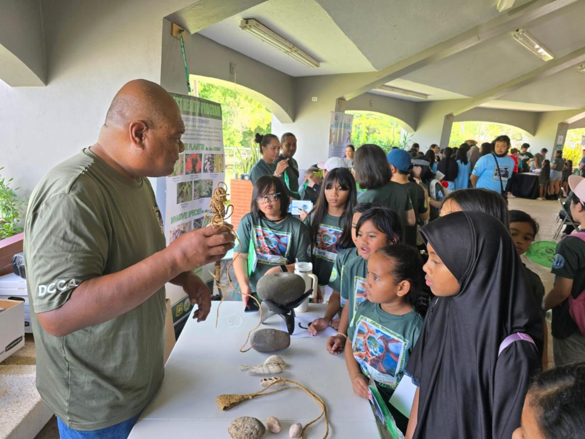 Jack Sablan of the CNMI Historic Preservation Office teaches school MYWAVE Club members about coconut fiber rope College during the Marianas Tourism Education Council Tourism Summit on Jan. 24, 2025, at Garapan Central Park in Saipan.