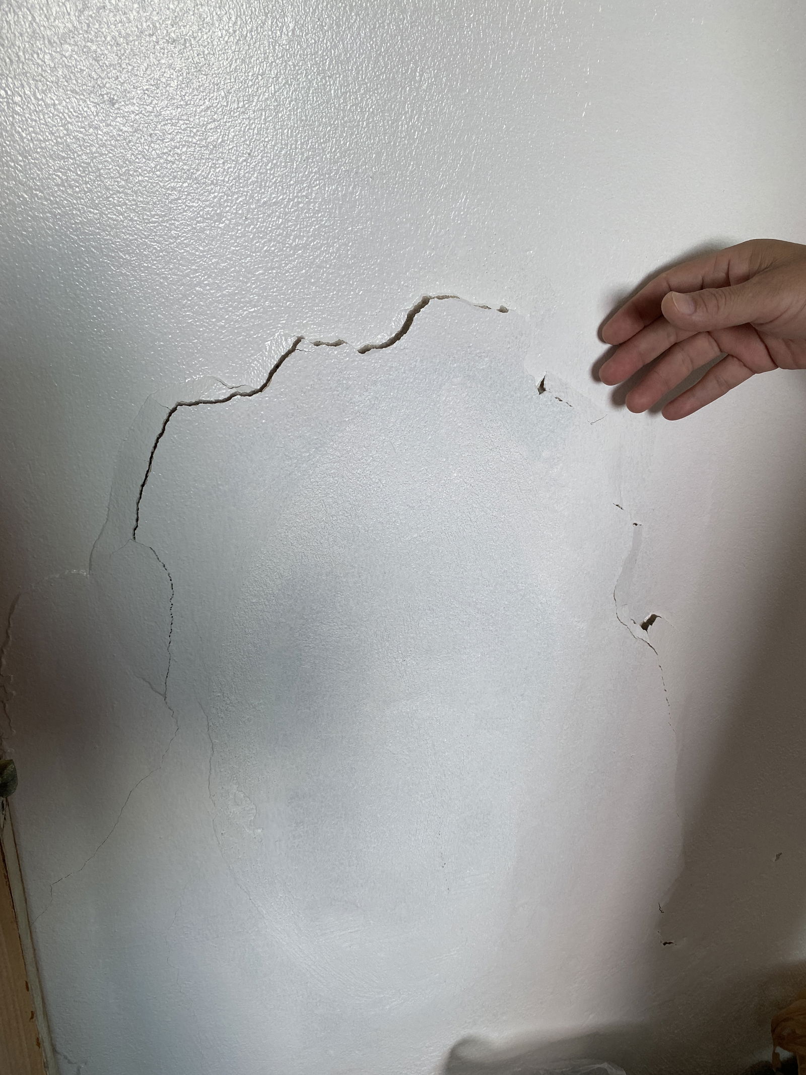 Daniel Durkin highlights a major crack on his apartment wall caused by expanding rebar.