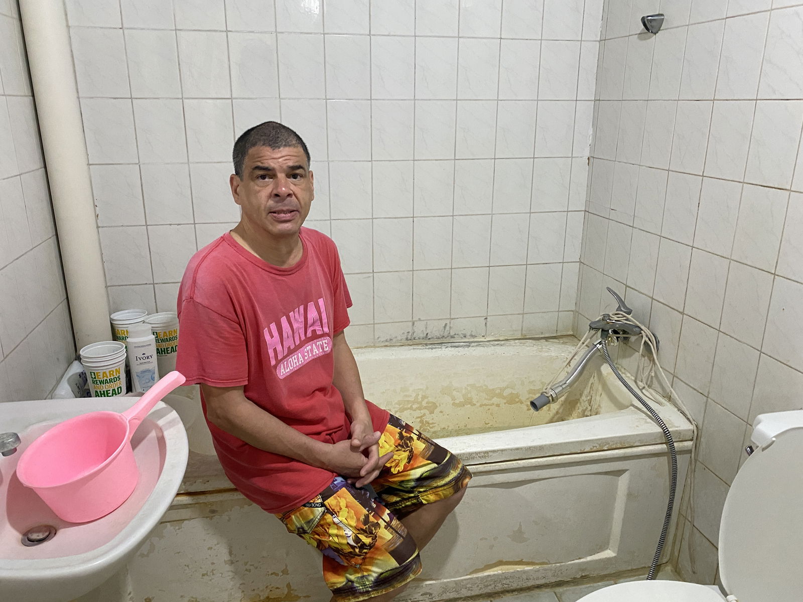 Daniel Durkin, a longtime resident of the CIC building, sits on his bathtub. He is going to court against CIC, which is seeking his eviction.