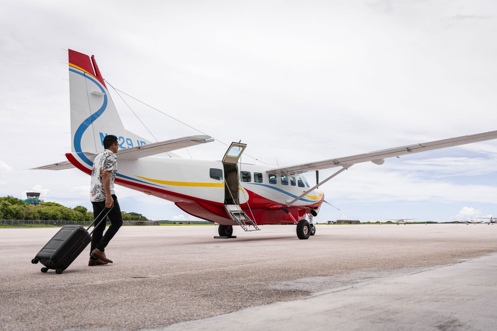 A passenger walks to a Micronesian Air Connection Service aircraft at the Francisco C. Ada/Saipan International Airport Commuter Terminal.