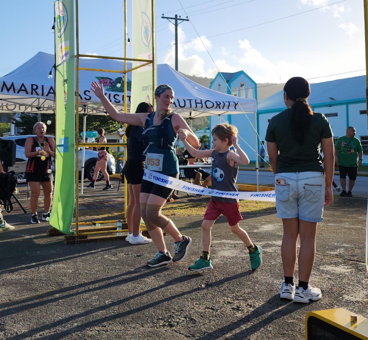 Sarah Faegre, left, crosses the finish line with her son after completing the half marathon in the 2nd Annual Rota Marathon on Jan. 18, 2025.