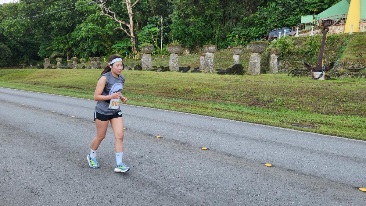 Ancient limestone monoliths called latte stones point the path forward for Dasom Kim of South Korea as she runs the half marathon course of the 2nd Annual Rota Marathon on Jan. 18, 2025. Rota is home to several U.S. National Historic Landmarks, including the Latte Stone Quarry at As Nieves.