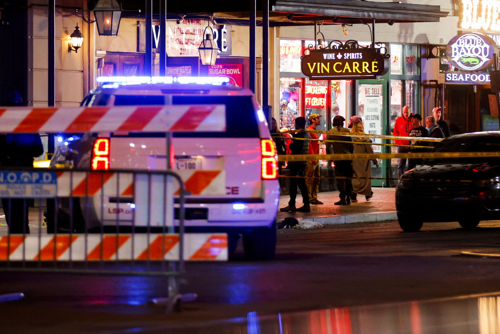 Law enforcement vehicles and people stand near the area where a vehicle drove into a crowd during New Year's celebrations, in New Orleans, Louisiana, Jan. 1, 2025.