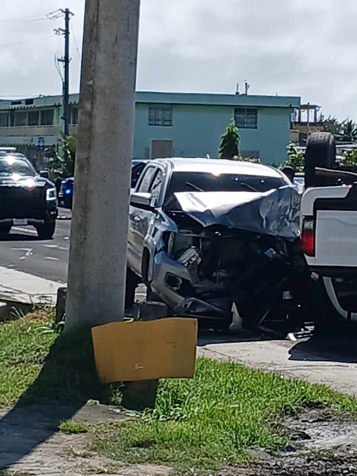 A truck’s front hood was severely damaged after colliding with another truck, which overturned from the impact on Middle Road, Thursday afternoon.
