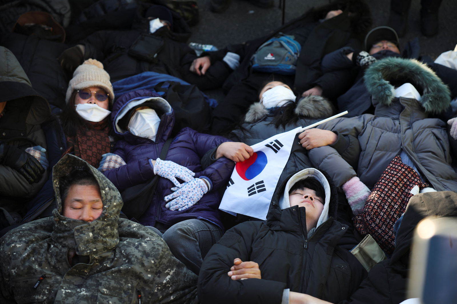 Pro-Yoon protesters lie on the ground outside of impeached South Korean President Yoon Suk Yeol's official residence as police officers attempt to disperse them in Seoul, South Korea, Jan. 2, 2025.