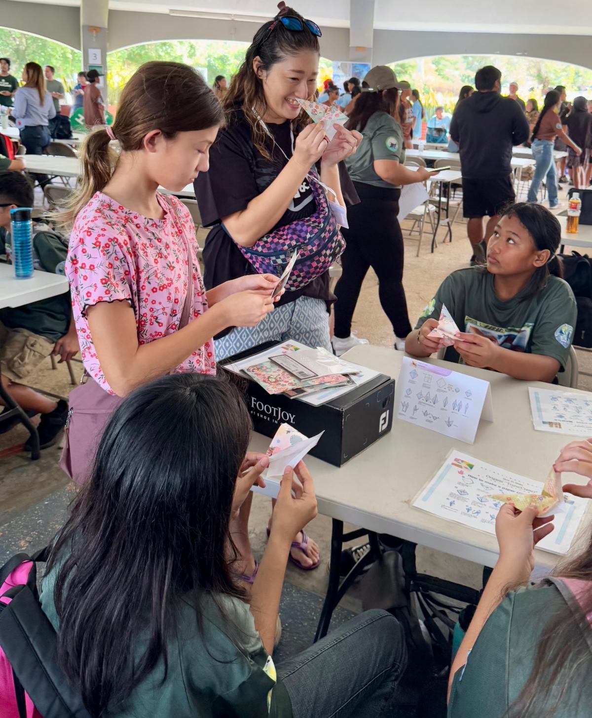 Students of MY WAVE Clubs learn to make paper cranes during the Marianas Tourism Education Council Tourism Summit on Jan. 24, 2025, at Garapan Central Park in Saipan. The clubs will fold 1,000 origami cranes to mark 80 years of peace in The Marianas since World War II.