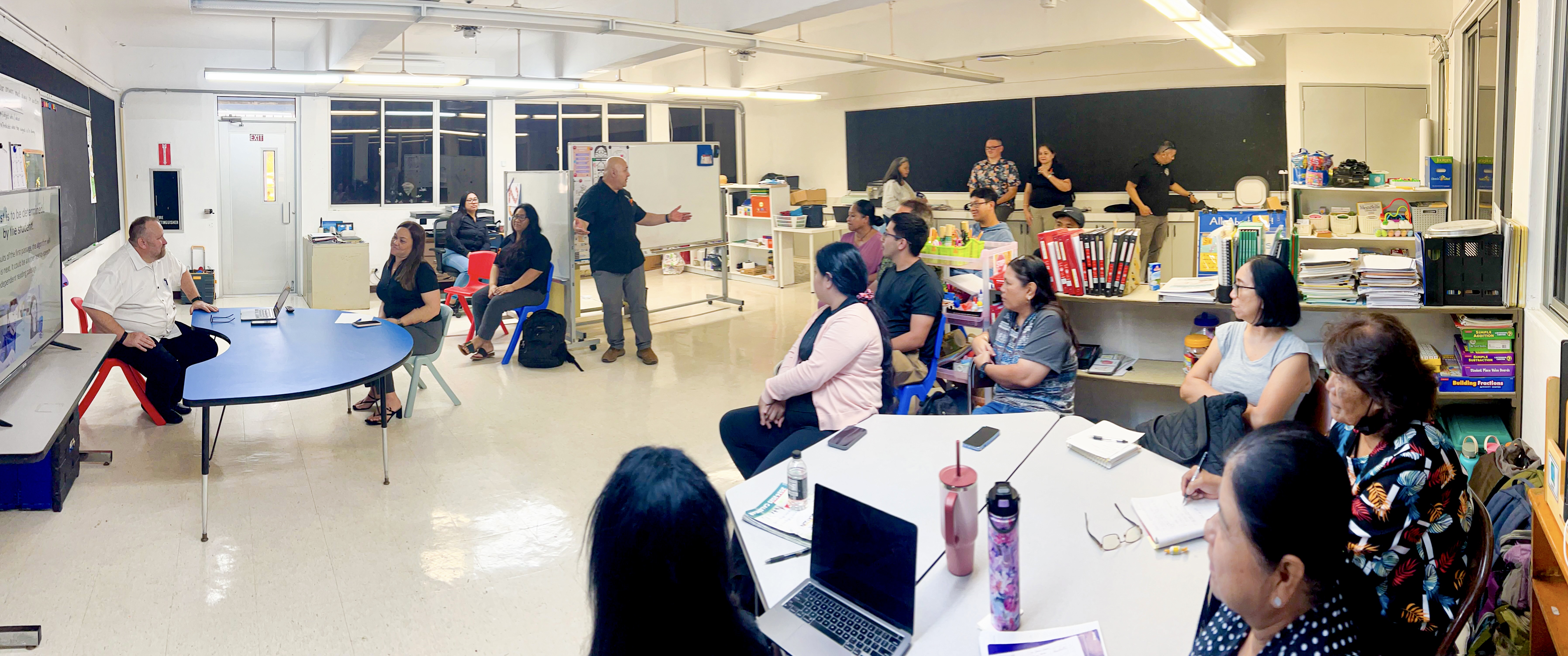 Commissioner of Education Dr. Lawrence F. Camacho, standing, gestures as he talks about the Public School System’s goal to improve the reading skills of all students.