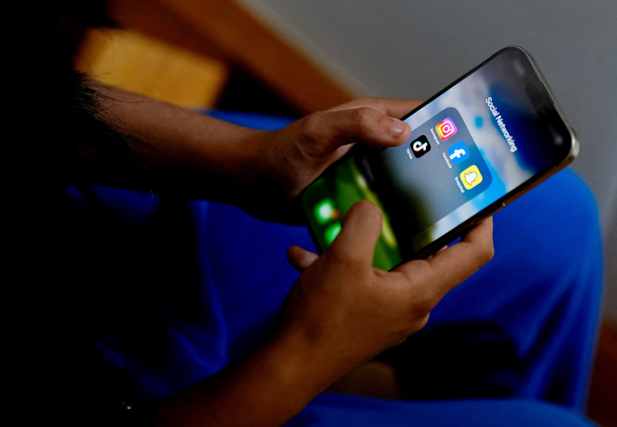 A high school student poses with her mobile showing her social media applications in Melbourne, Australia, Nov. 28, 2024.