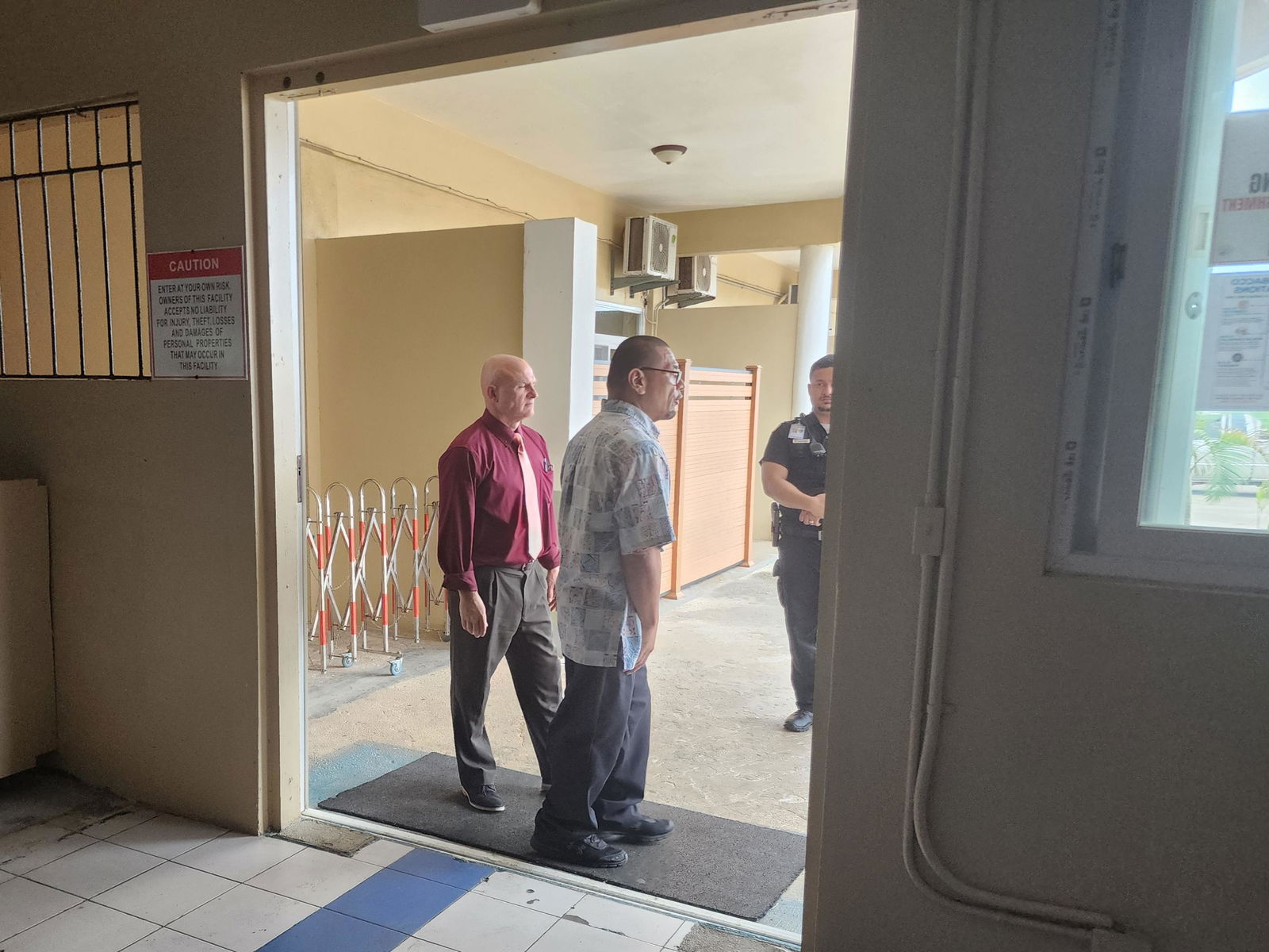 Defense attorney Joey McDoulett stands with defendant Calvin Tagabuel at the entrance of Cool Laundry.
